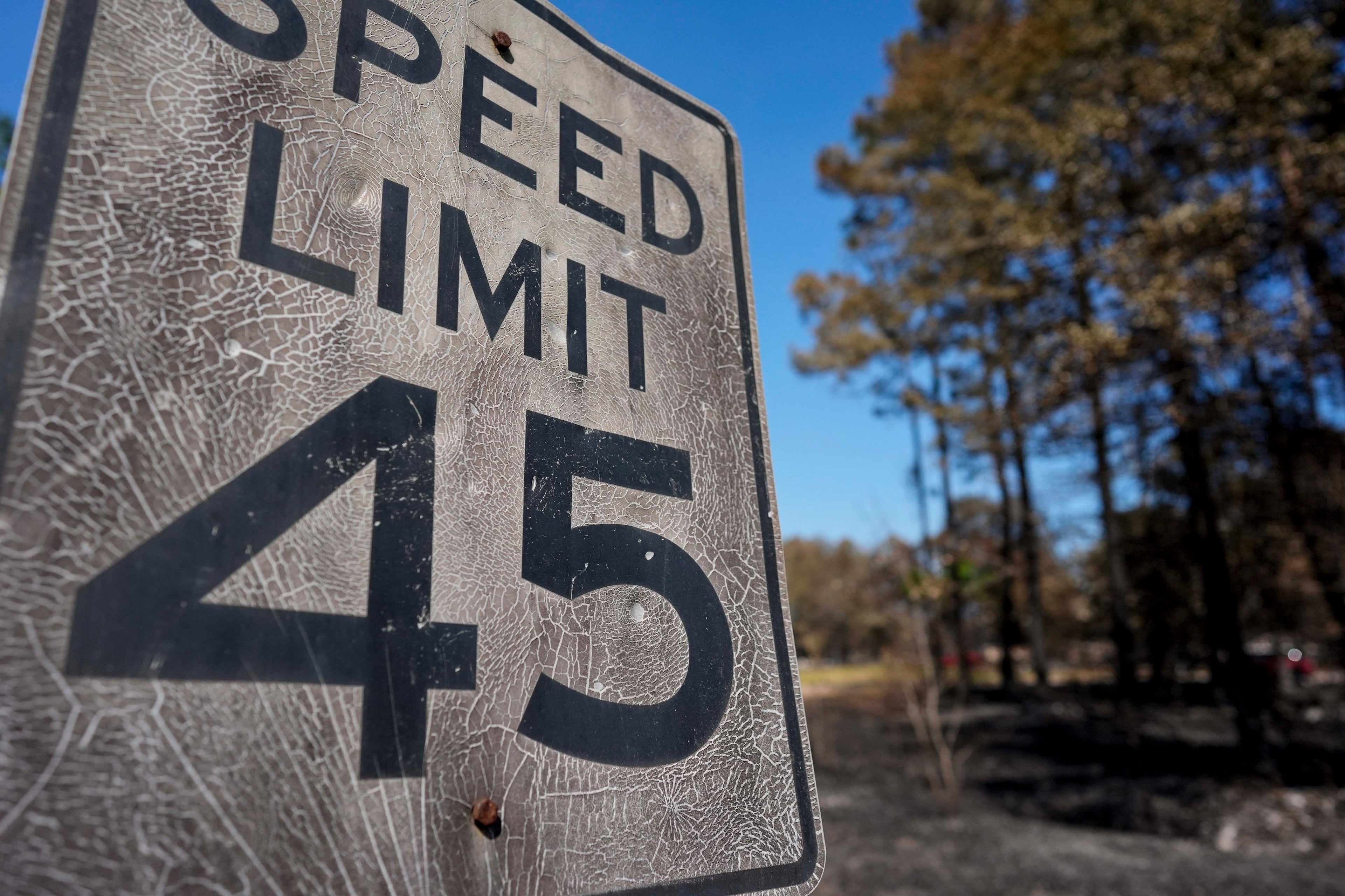 A burned speed limit sign stands near destroyed homes as the Brantley Highway 82 fire burns on Thursday, April 23, 2026, near Nahunta. (Mike Stewart/AP)