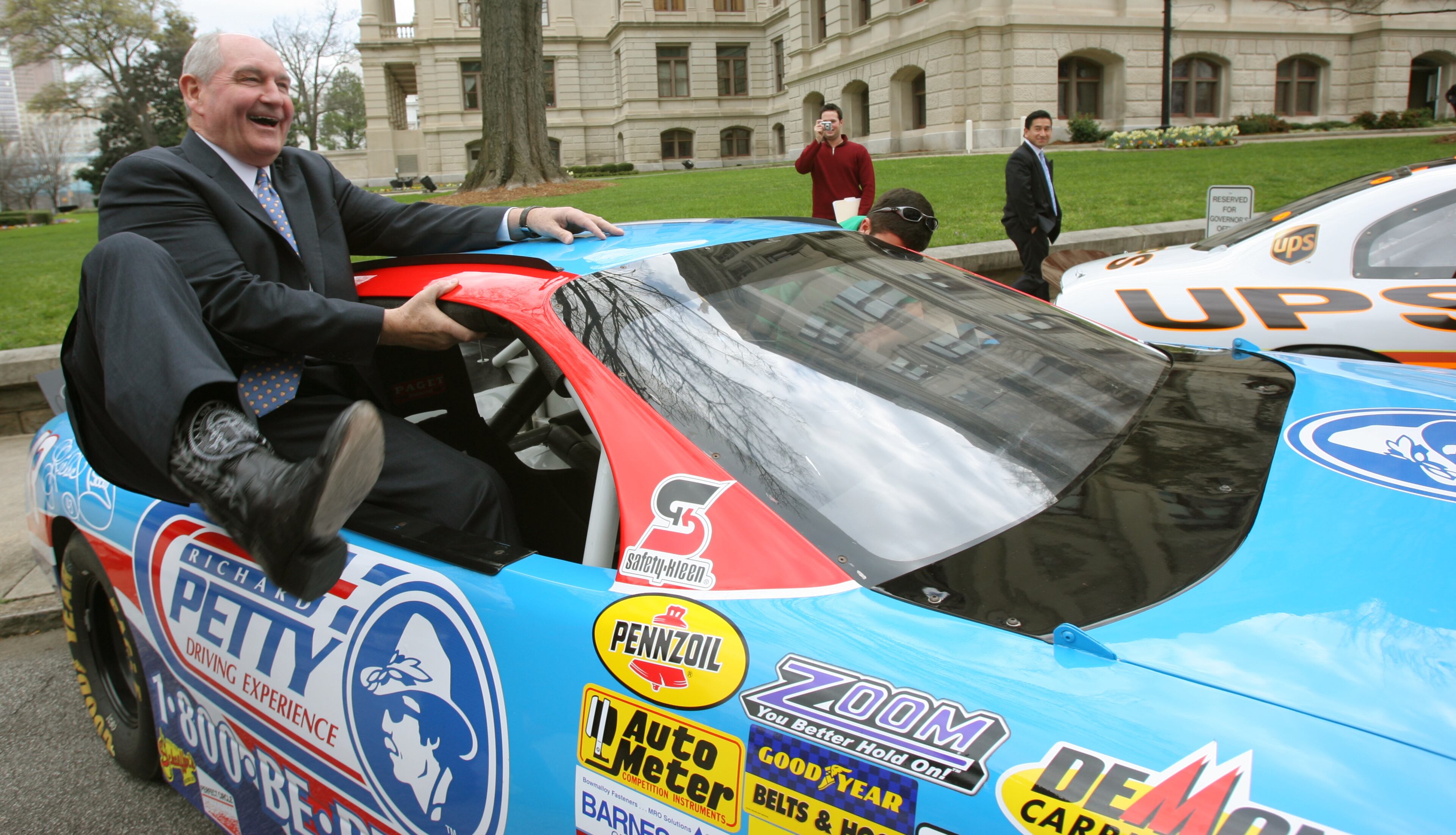 060316 - ATLANTA, GA -- Gov. Sonny Perdue (cq) climbs into a Richard Petty Driving Experience car Thursday morning, March 16, 2006 to do a burn-out and take a lap around the Capitol with NASCAR drive Reed Sorenson (cq) to celebrate Atlanta Motor Speedway Day. After the lap the two switched seats and Perdue took Sorenson for a lap. (BEN GRAY/AJC staff)