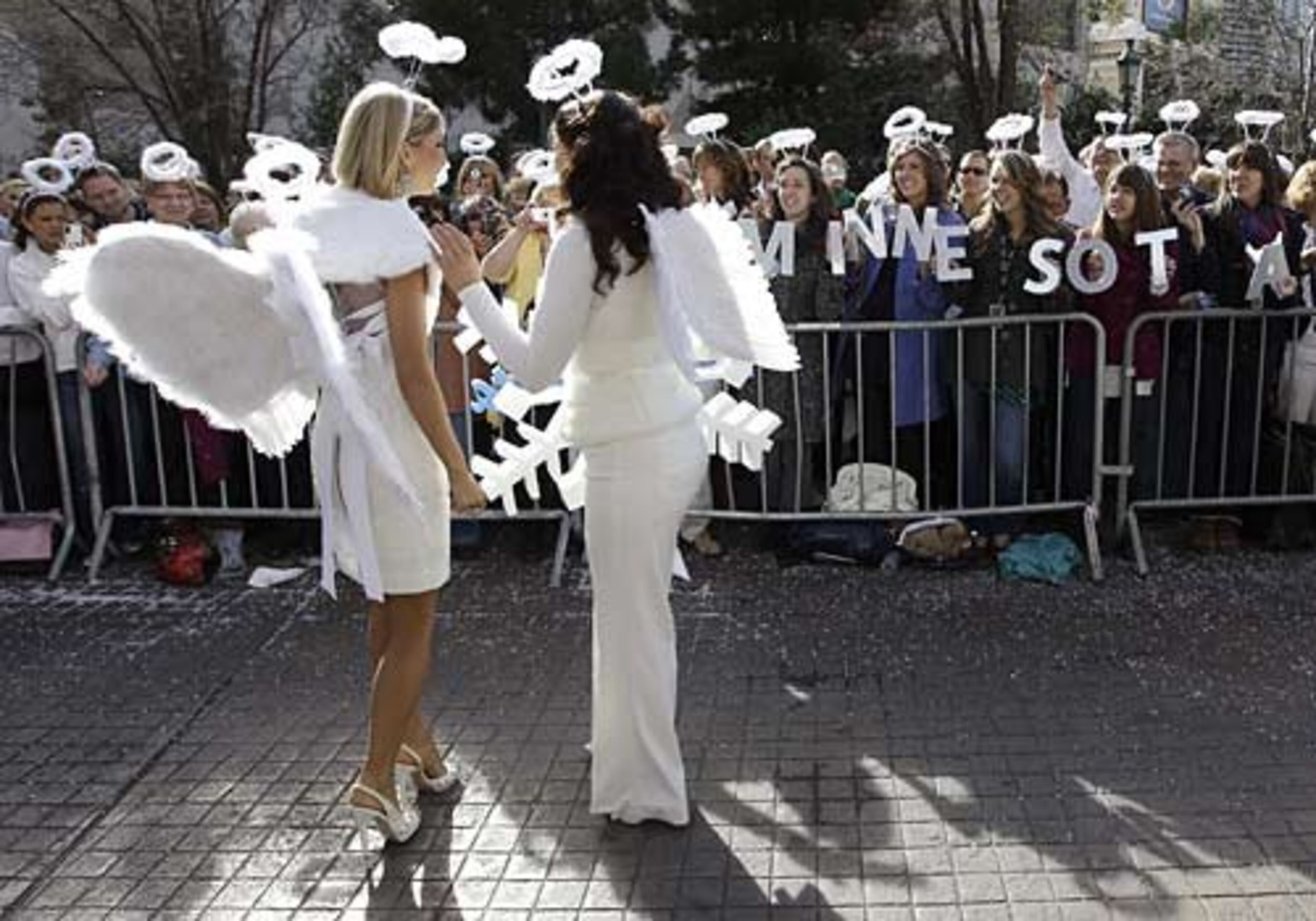 Kathryn Knuttila (left), Miss Minnesota, stops to have her photo taken by spectators from her home state.