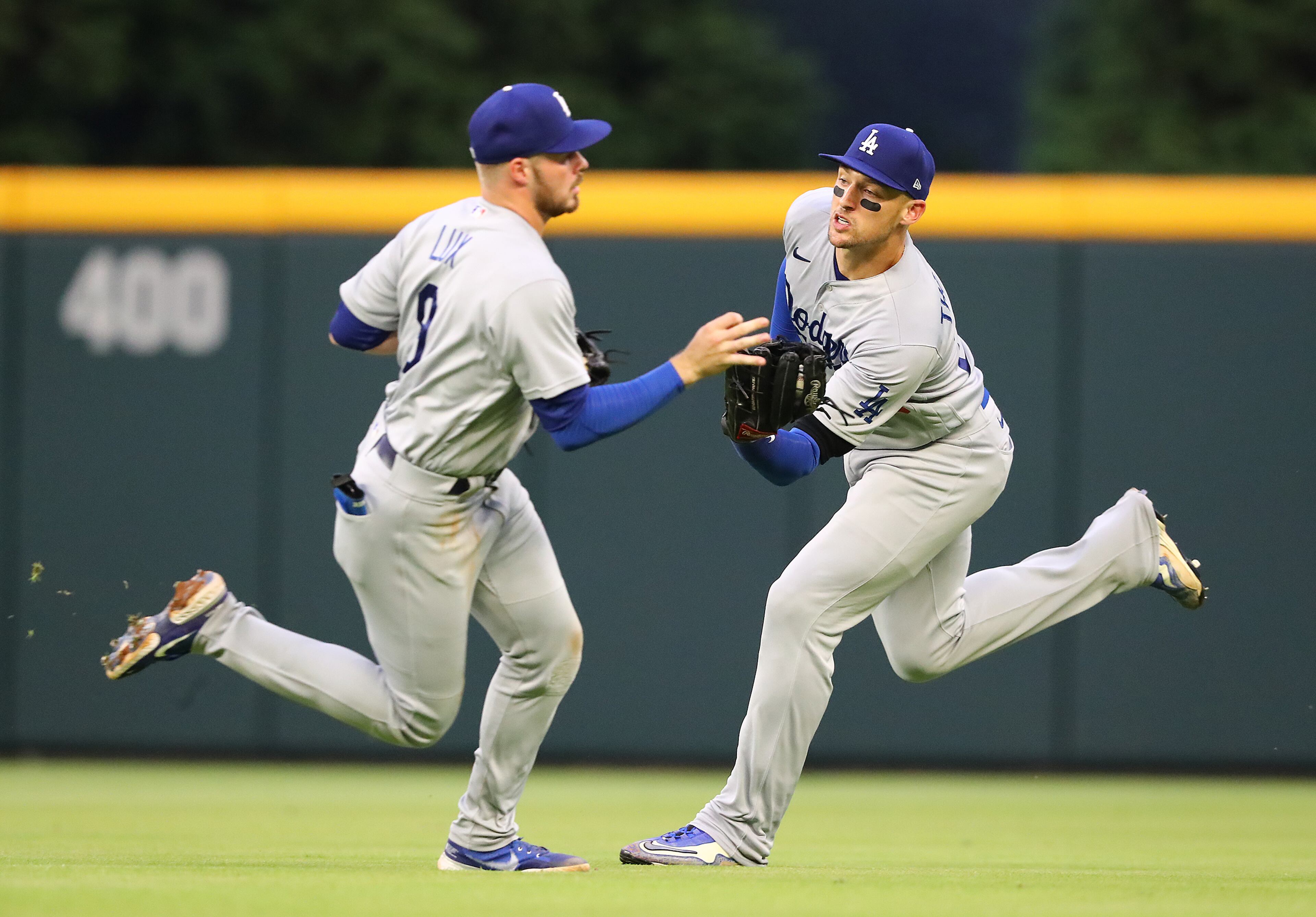 Dodgers outfielder Trayce Thompson (right) runs down a fly ball hit by Atlanta's Orlando Arcia and avoids a collision with Gavin Lux during the fourth inning in an MLB game on Sunday at Truist Park. (Curtis Compton / Curtis.Compton@ajc.com)