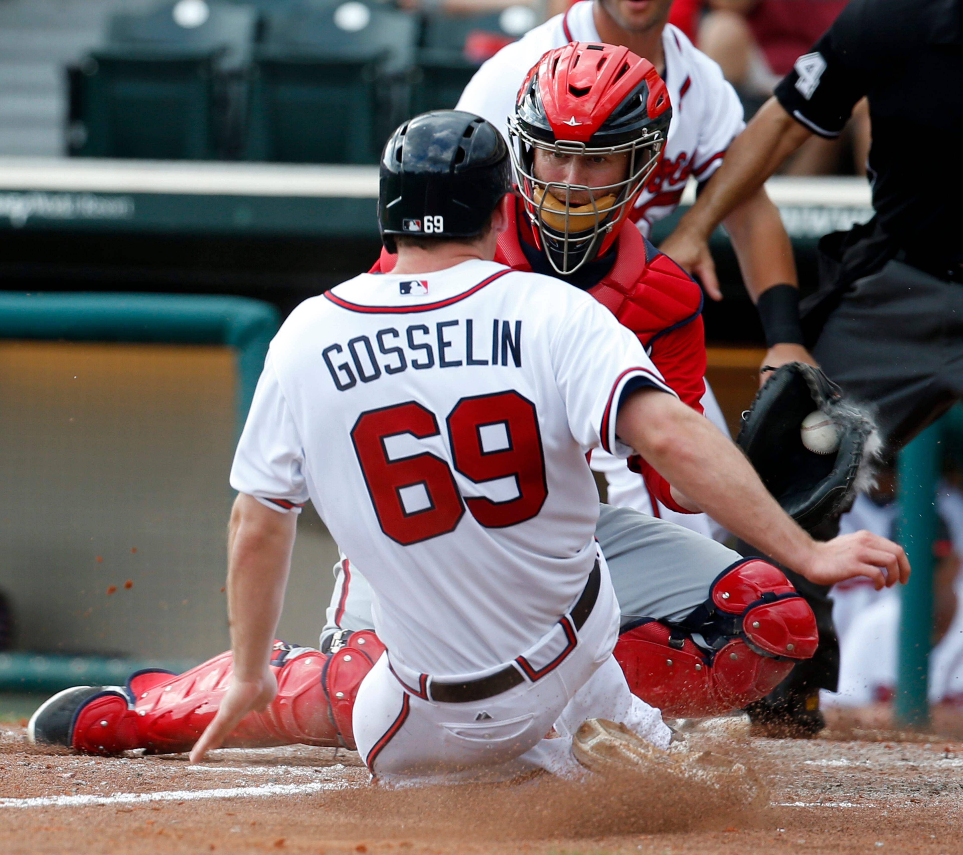 Atlanta Braves' Phil Gosselin is safe at home as Washington Nationals catcher Koyie Hill covers the plate in the seventh inning of an exhibition baseball game, Tuesday, March 4, 2014, in Kissimmee, Fla. The Braves won 8-4.