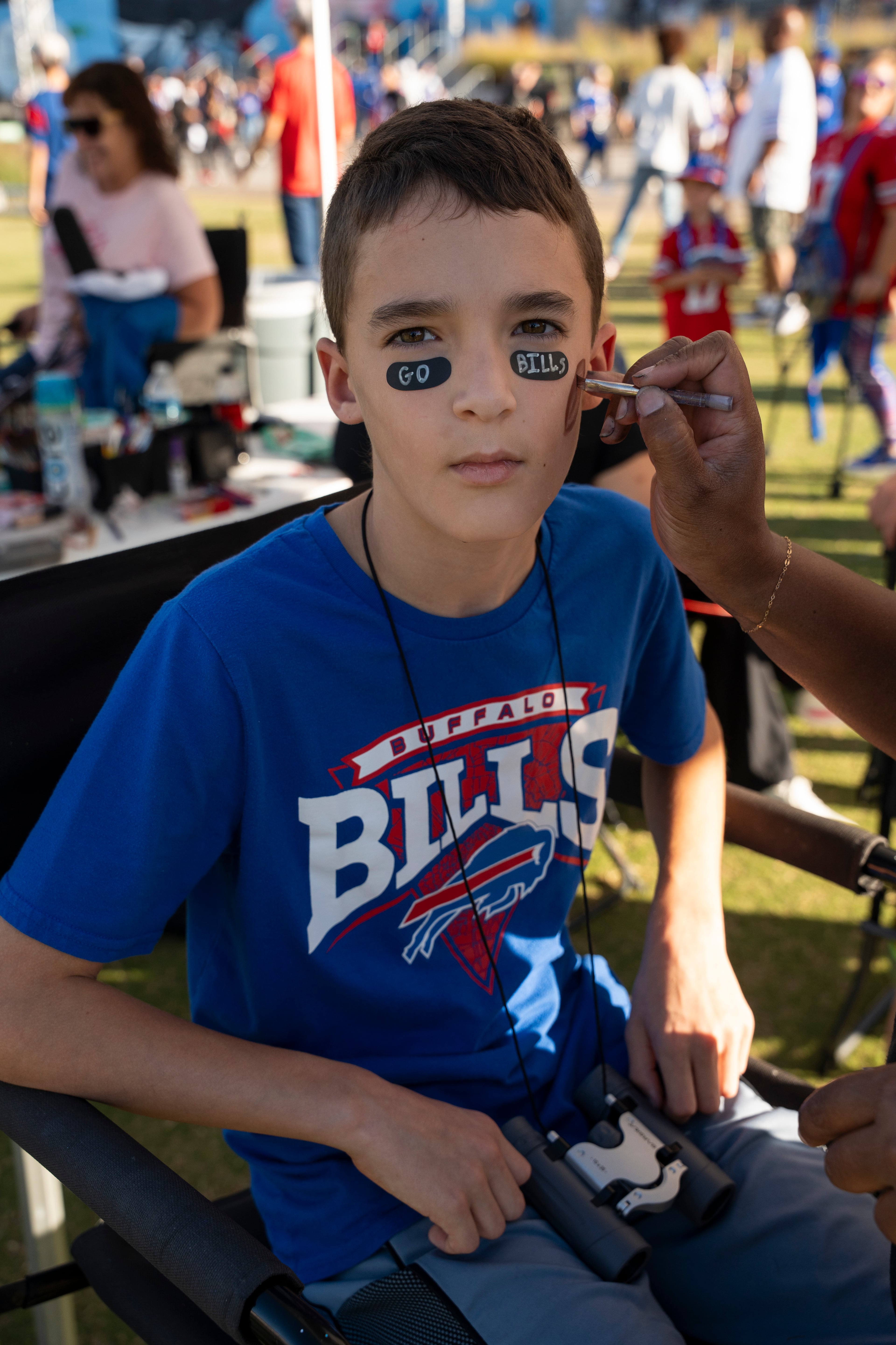 Elam Fuerch, 10, gets “Go Bills” painted on his face while tailgating with his family outside Mercedes-Benz Stadium on Monday, Oct. 13, 2025, in Atlanta. Elam traveled with his mom and brother two and a half hours to attend the Monday Night Football game between the Buffalo Bills and the Atlanta Falcons. (Olivia Bowdoin for the AJC)