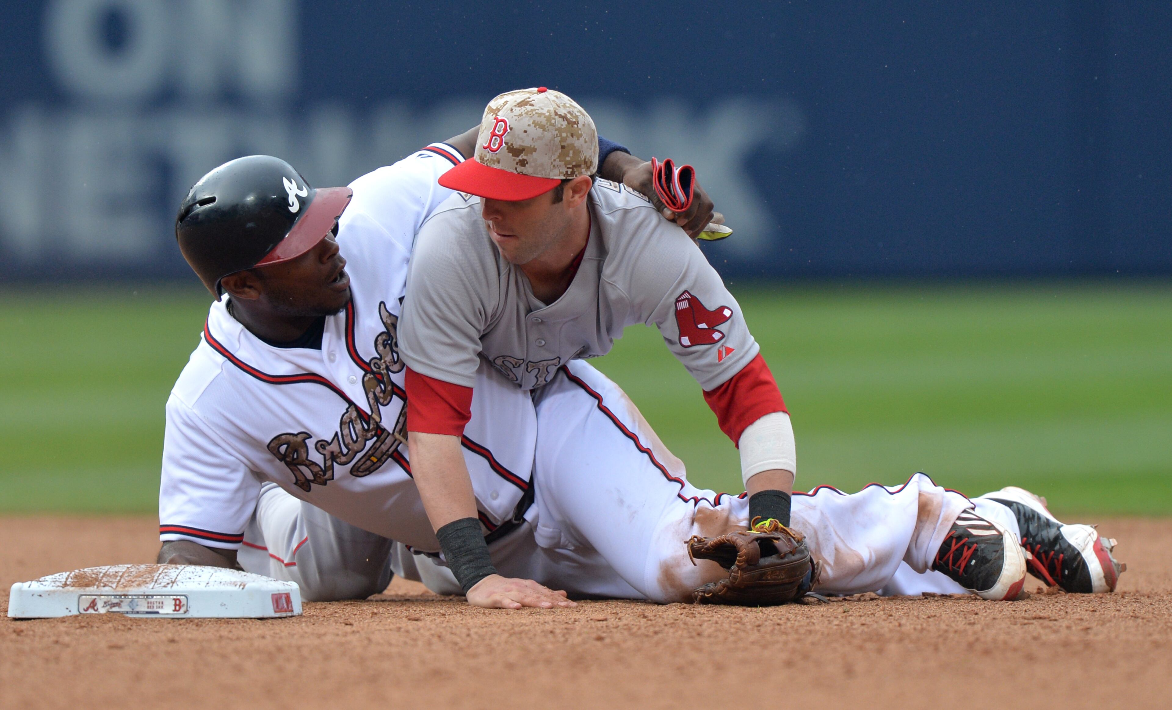 Justin Upton wraps his are around Boston Red Sox second baseman Dustin Pedroia after attempting to break up a double play in the bottom of the 6th inning Monday May 26, 2014 at Turner Field BRANT SANDERLIN /BSANDERLIN@AJC.COM