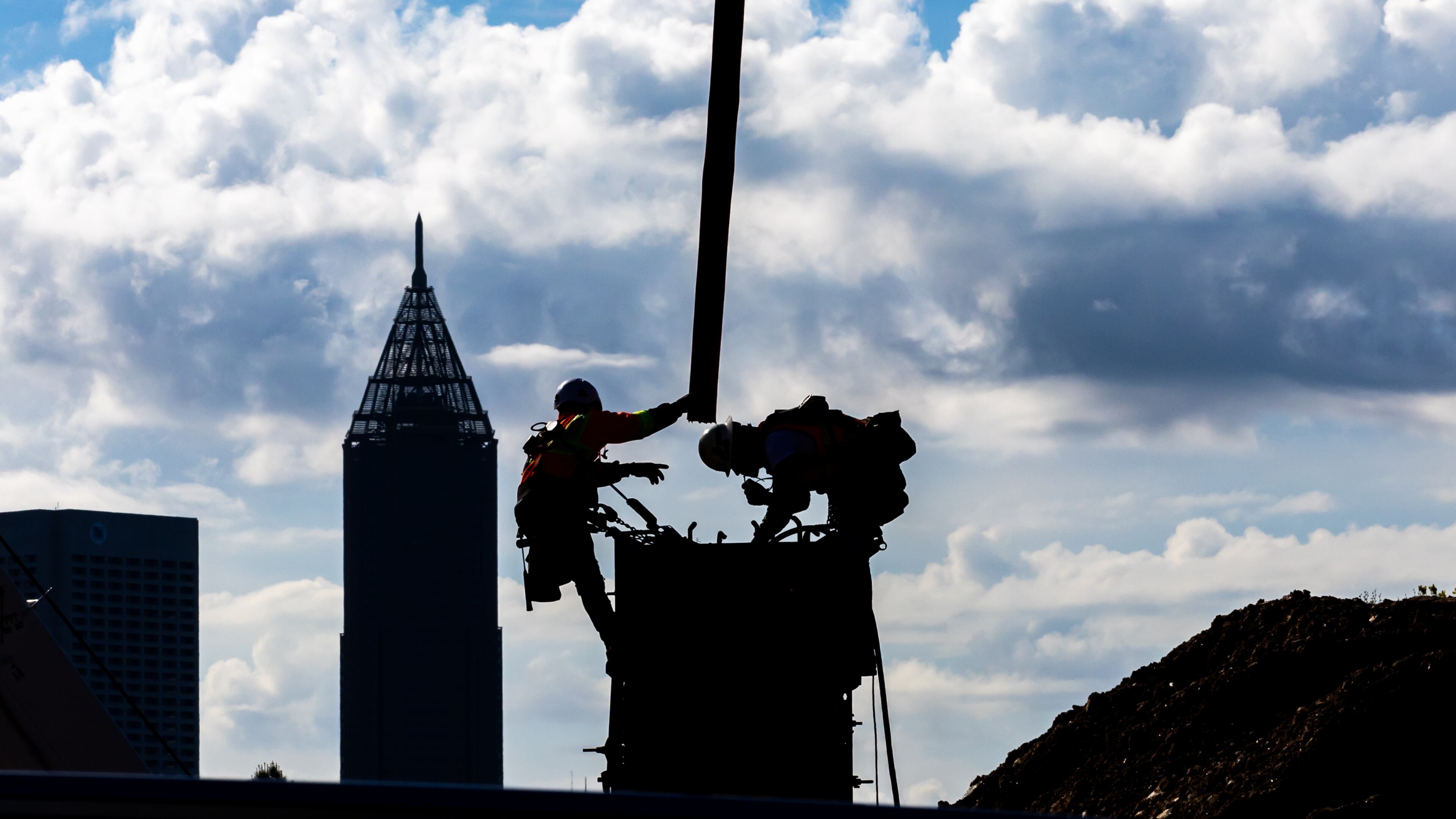 Blue skies with bold cloud formations painted the backdrop against the skyline for construction workers pouring concrete into forms along Bishop Street near 17th Street in West Midtown Atlanta on Thursday, March 28, 2024 where Southeastern Development Brokerage Consulting is developing a mixed-use project called UrbA ATL which will have 321 luxury apartments and about 27,000 sf of retail and restaurants. (John Spink / John.Spink@ajc.com)