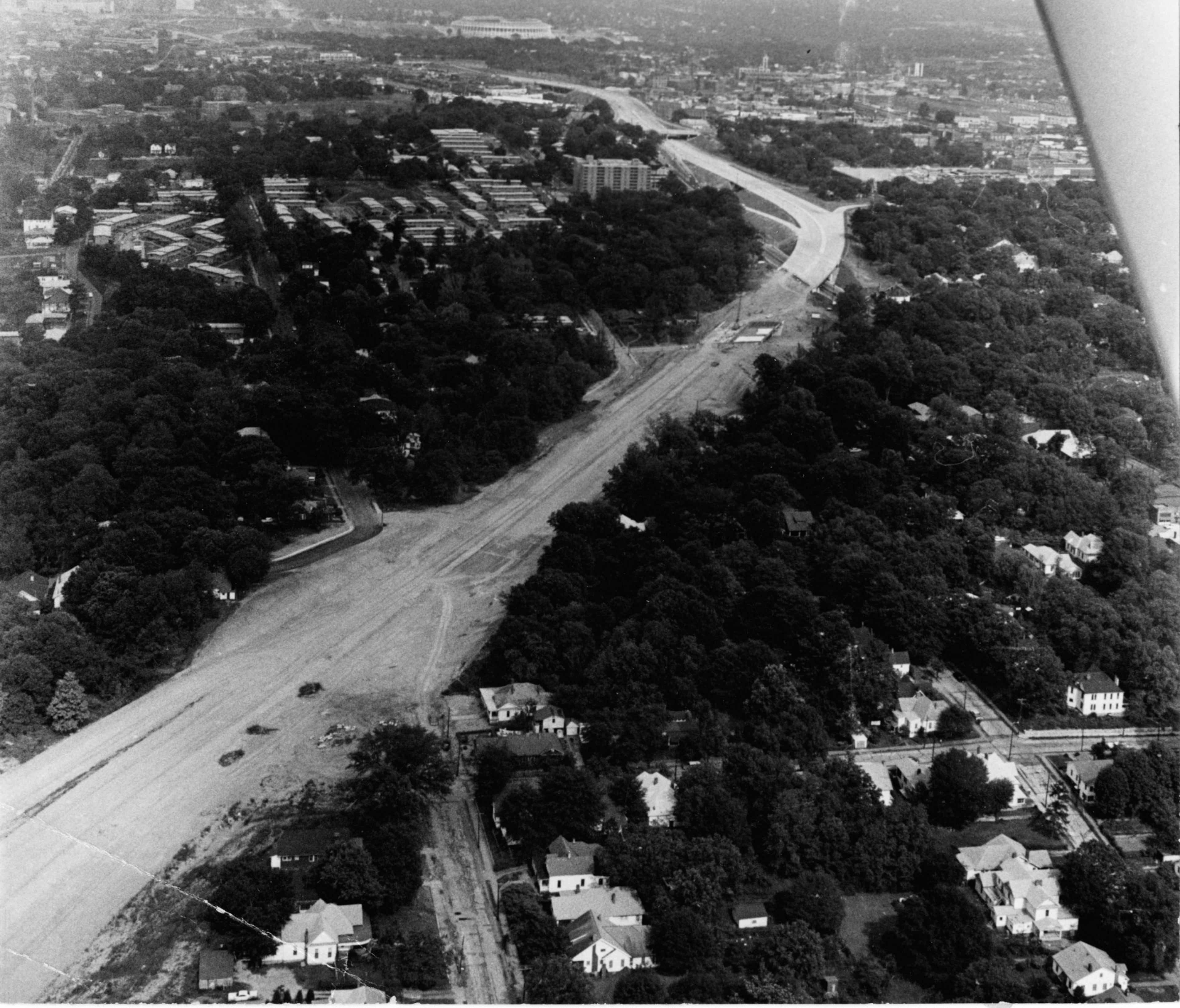 May 1965 - (Looking eastward) Atlanta, Ga.: - Aerial view shows I-20 paving ending and dirt leveled right-of-way continuing westward. In upper middle of photo and distance Atlanta's new stadium can be seen.