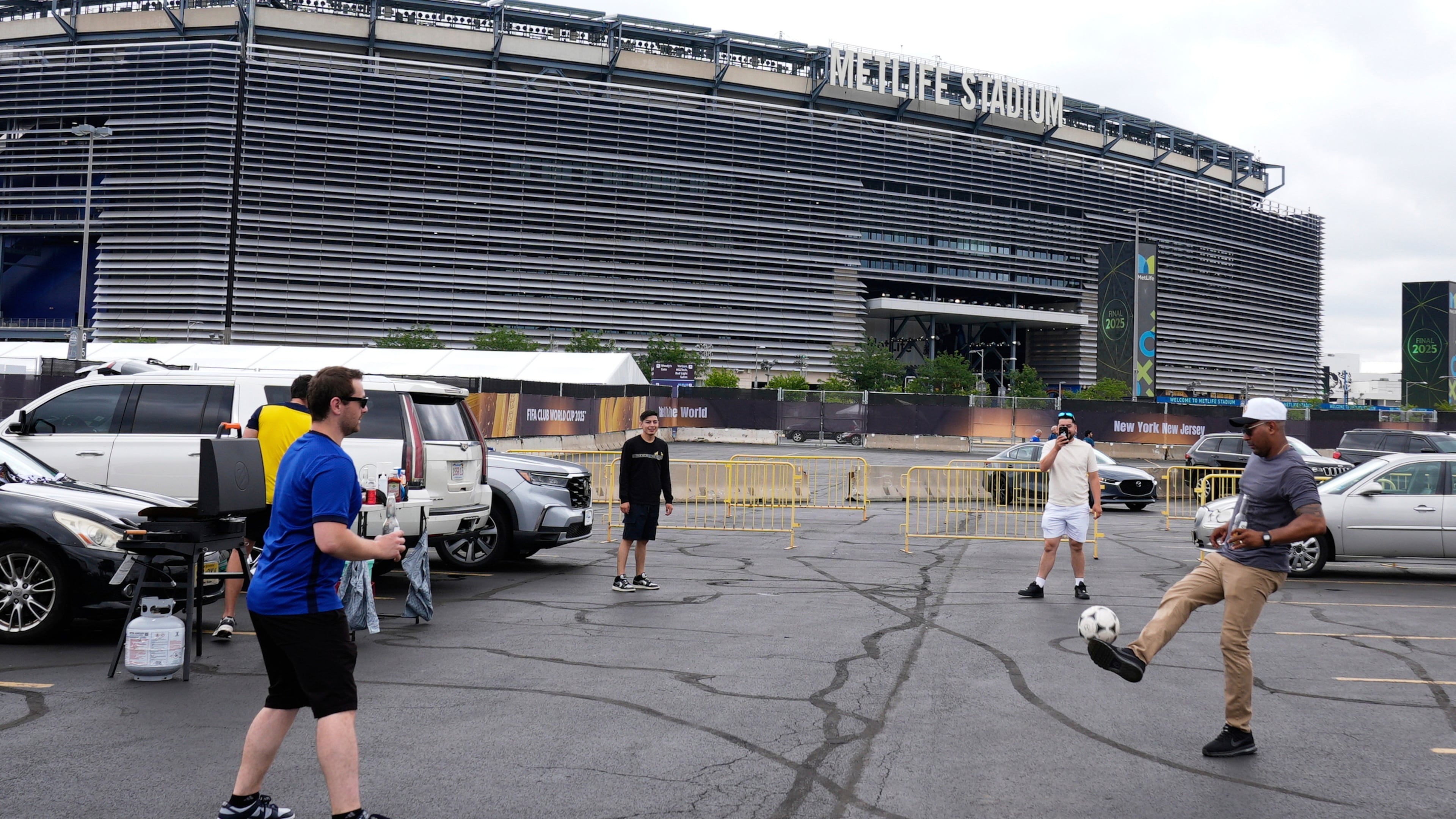 FILE - Fans play with a ball outside the Metlife Stadium prior to the Club World Cup final soccer match between Chelsea and PSG in East Rutherford, N.J., Sunday, July 13, 2025. (AP Photo/Pamela Smith, File)