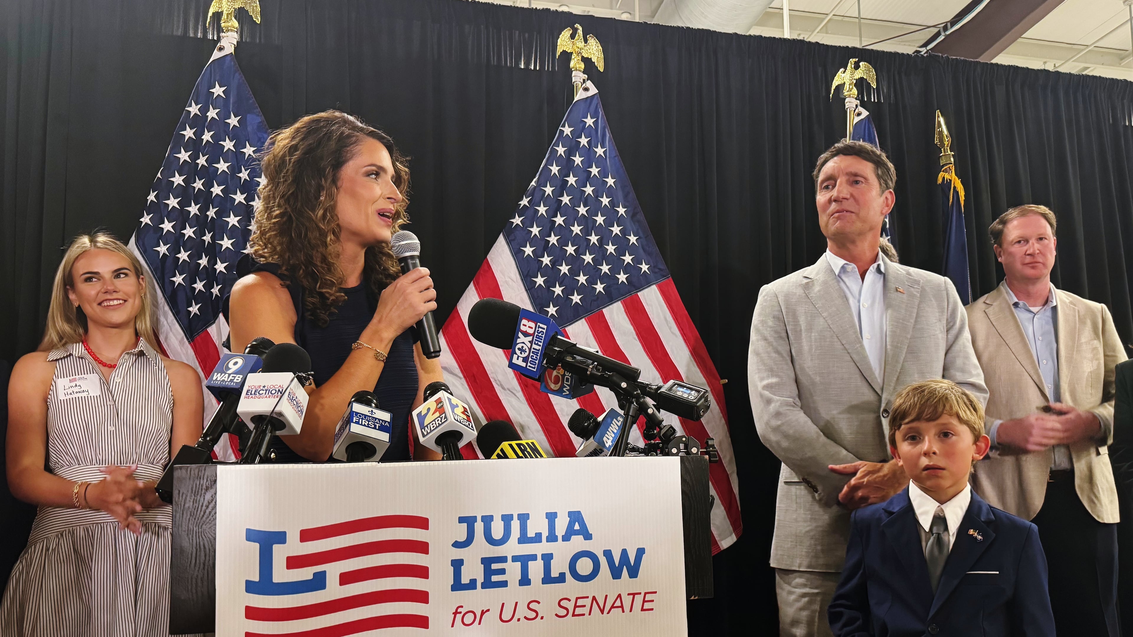 U.S. Rep. Julia Letlow, standing beside her fiancee Kevin Ainsworth, center right, and her son, addresses her supporters in Baton Rouge, La., Saturday, June 27, 2026, after winning the GOP Senate nomination. (AP Photo/Jack Brook)