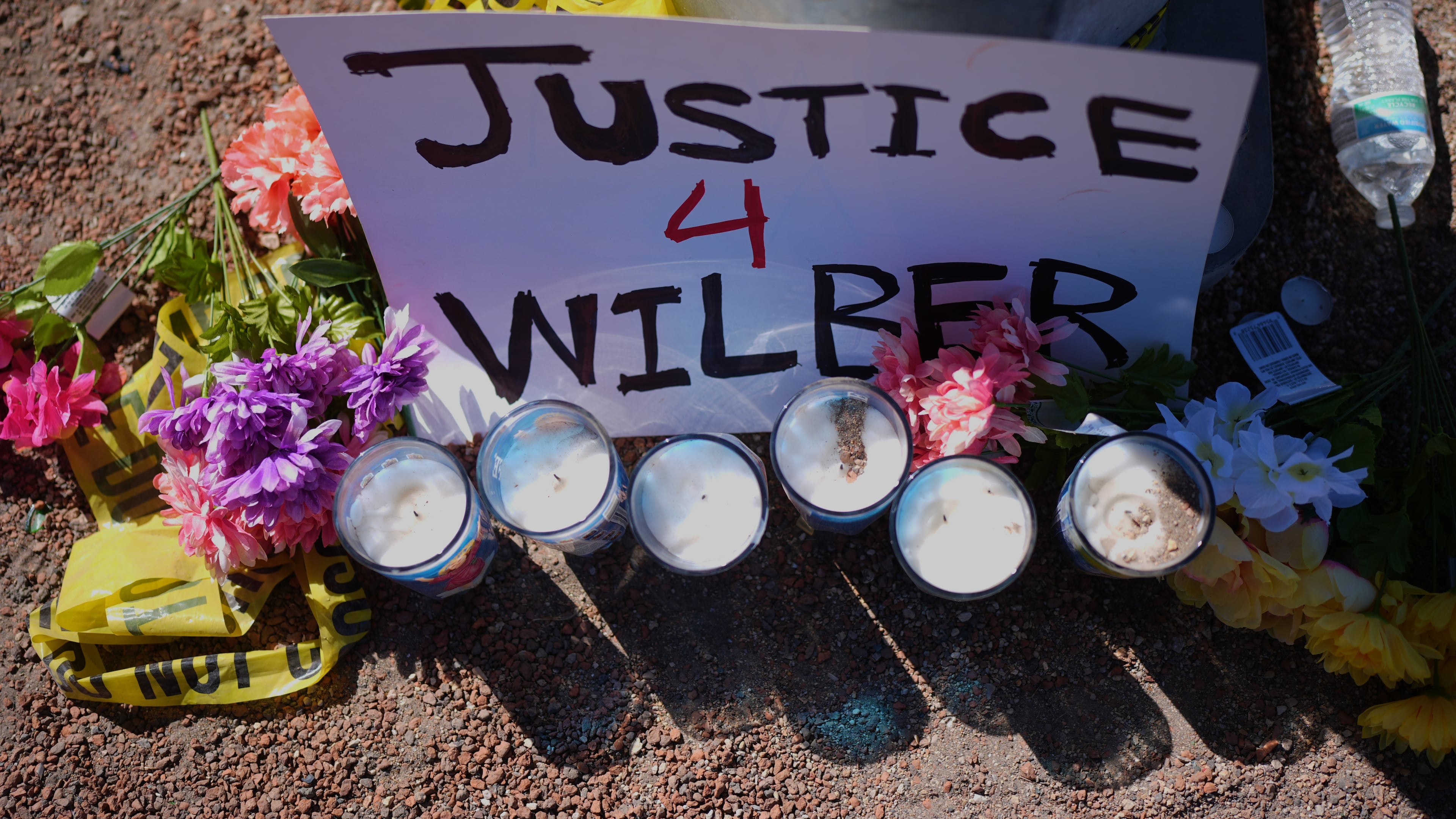 Flowers and candles are seen near the site where a Venezuelan man was shot in his vehicle by an ICE officer in Austin, Texas, Monday, Sept. 21, 2026. (AP Photo/Eric Gay)