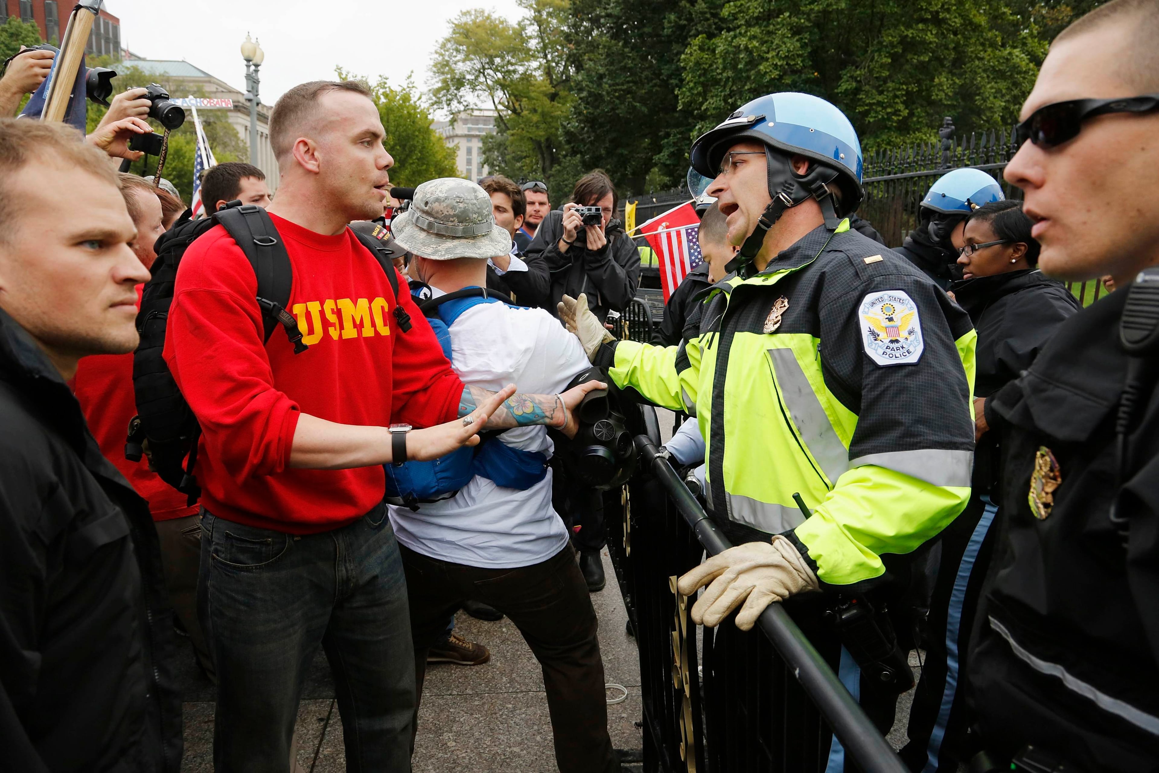 Law enforcement officers force protesters down from the fence in front of the White House gates in Washington, October 13, 2013. The protesters, from the "Million Vet March on the Memorials", were rallying against the closure of the U.S. National World War Two Memorial due to the current U.S. government shutdown. REUTERS/Jonathan Ernst