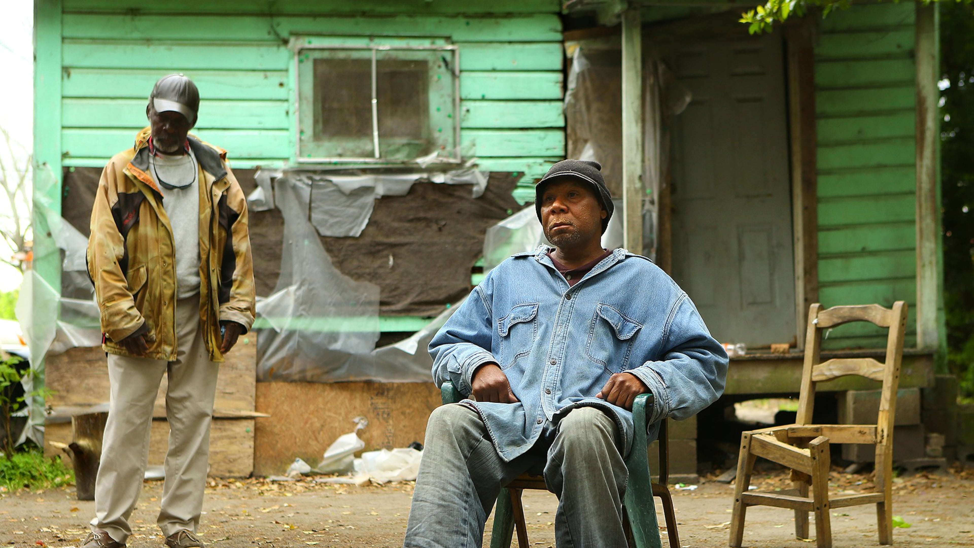 Adel Edwards, 54, sits outside his Pelham home by a small pile of leaves with his friend Henry Smith. Edwards was fined $500 for burning leaves without a permit and placed on probation to make payments. In a lawsuit, Edwards alleges he was jailed when he couldn’t afford to make a day-of-court payment demanded by the court’s probation company. Curtis Compton / ccompton@ajc.com