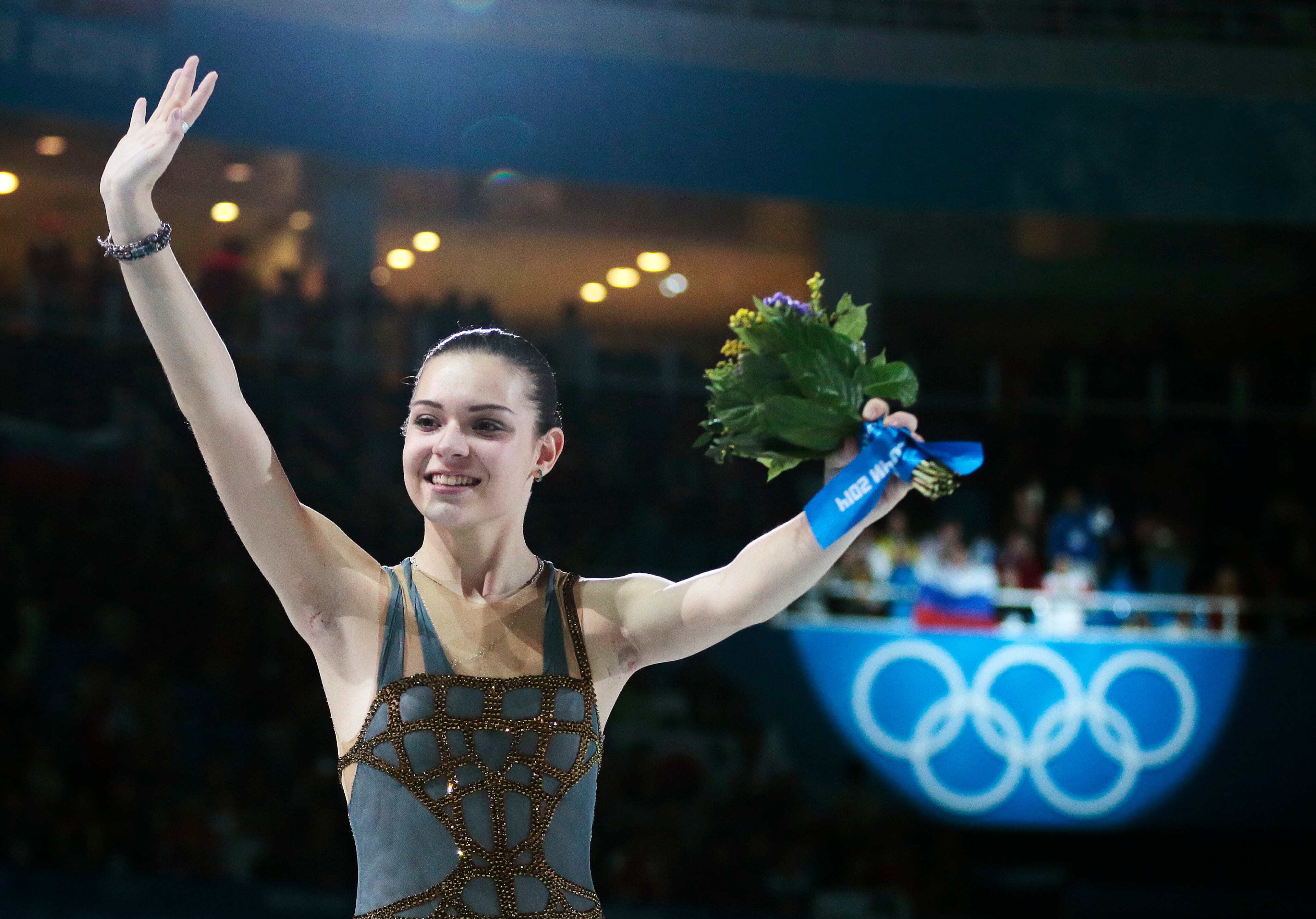 Adelina Sotnikova of Russia celebrates after placing first during the flower ceremony for the women's free skate figure skating final at the Iceberg Skating Palace during the 2014 Winter Olympics, Thursday, Feb. 20, 2014, in Sochi, Russia. Sotnikova placed first, followed by Kim and Kostner. (AP Photo/Ivan Sekretarev)