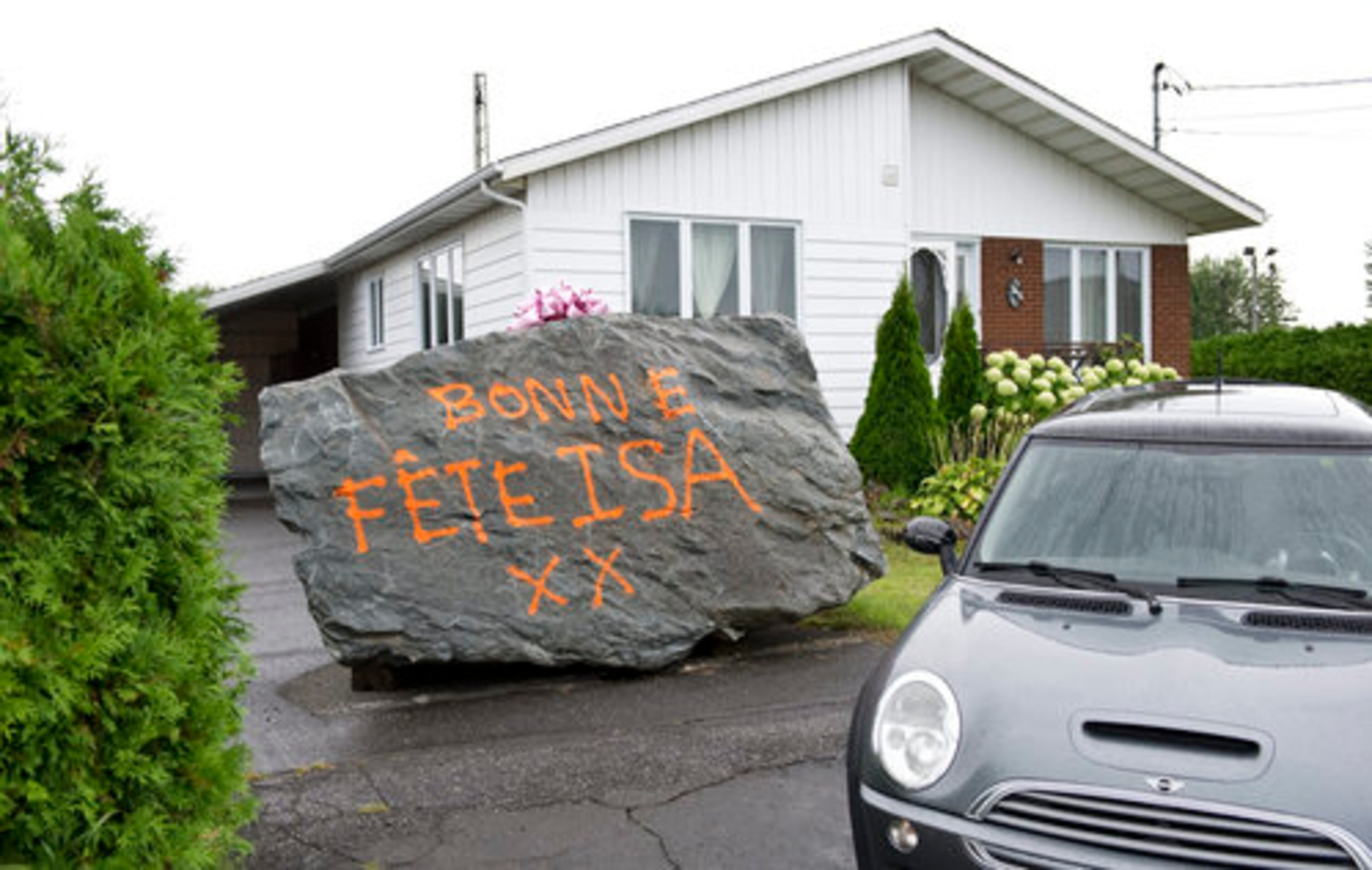 SHE WANTED A "BIG ROCK"--A boulder topped with a ribbon and covered in a spray-painted message: "Happy birthday, Isa" sits in the driveway of Isabelle Prevost, Monday, Aug. 15, 2011, in Acton Vale, Quebec. The 20-ton stone was left there as a gift by Dany Lariviere, Prevost's ex-husband and mayor of a nearby municipality, following lengthy divorce proceedings. Lariviere joked that his wife had always wanted a big rock and he quipped that this one is, in his words, between 18 and 24 "carat-tons."