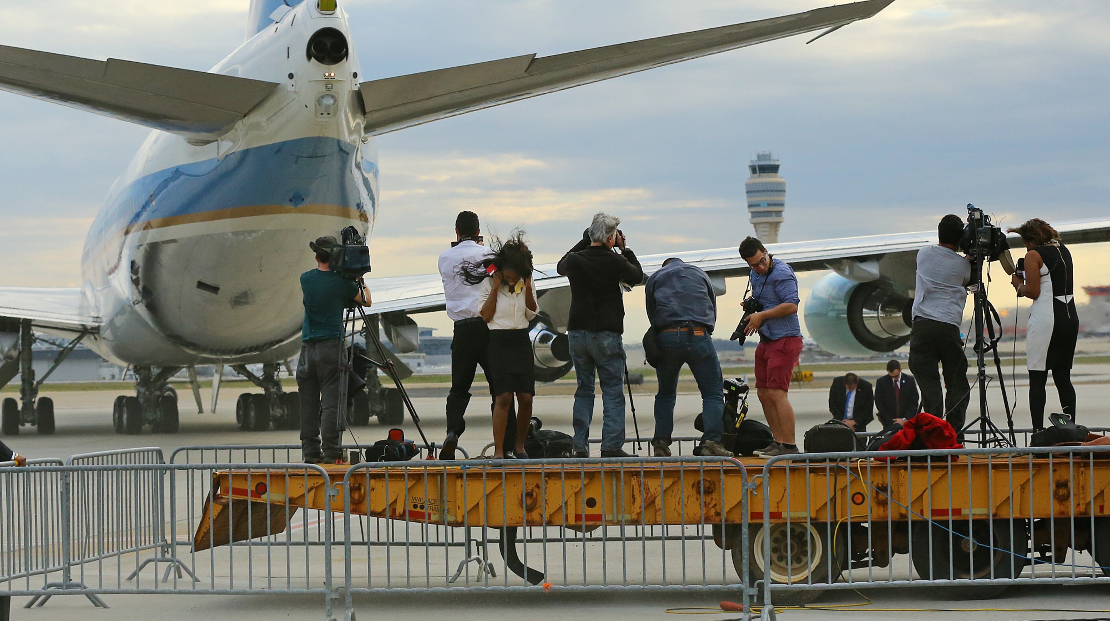Members of the local news media on a platform are blasted by the jet wash while covering Air Force One pulling away as President Barack Obama leaves on Tuesday, March 10, 2015, in Atlanta. Curtis Compton / ccompton@ajc.com