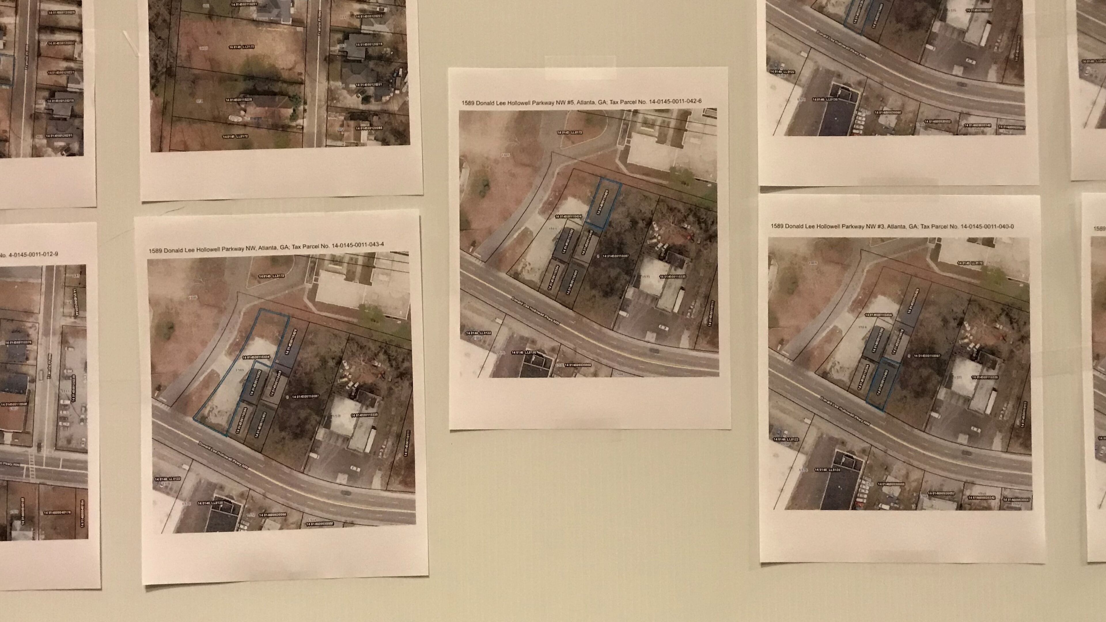 Aerial photos of properties that Atlanta Public Schools seeks to acquire through eminent domain are displayed during a school board meeting on Aug. 6.