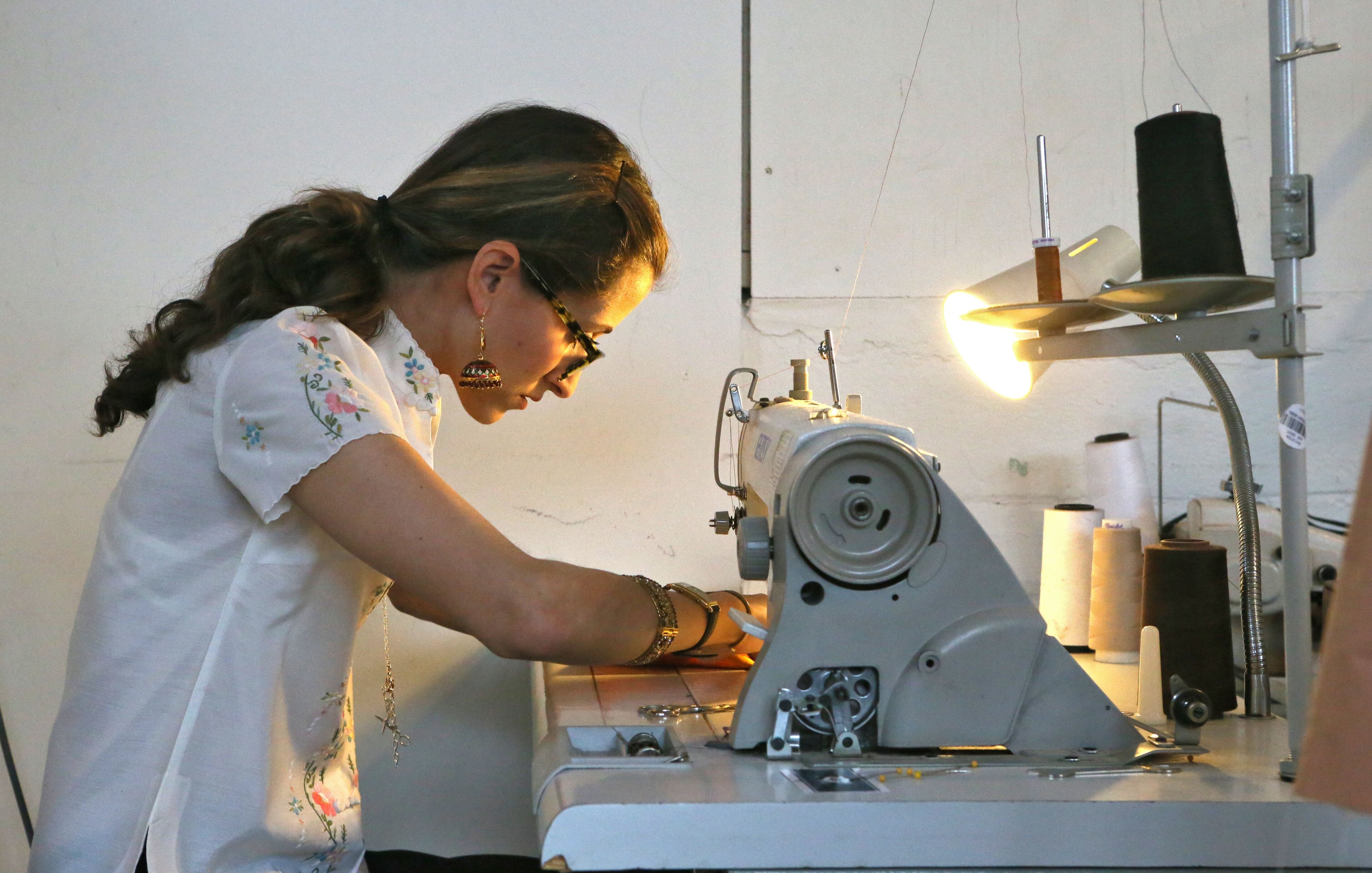 Local fashion designer Tian Justman works in her Atlanta studio. Her new collection gets a runway show in conjunction with Théâtre du Rêve's theatrical production "So Coco" about Coco Chanel. BOB ANDRES / BANDRES@AJC.COM