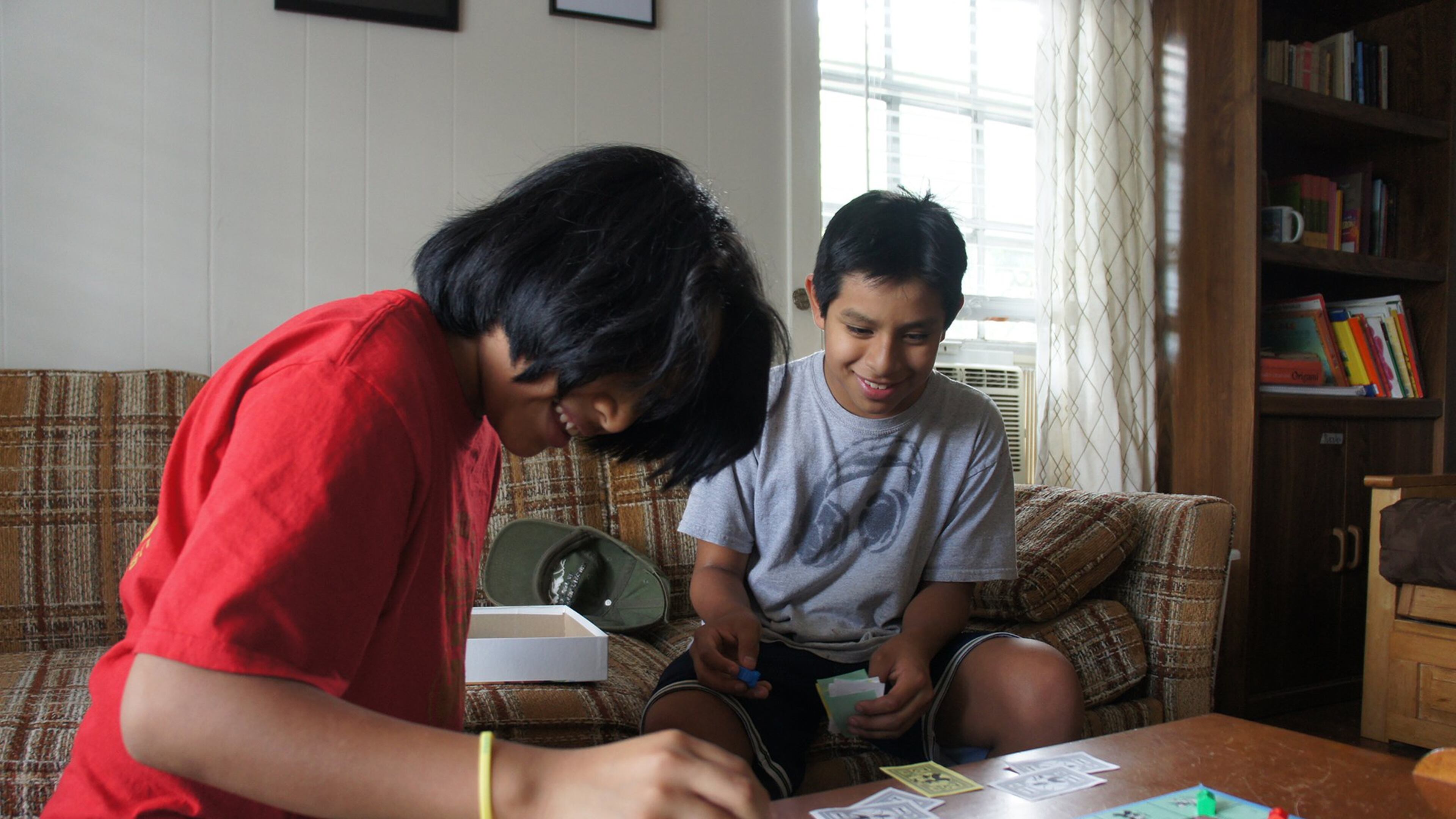 Javy (left) and Teo McGinnis, 12-year-old twin sons of El Refugio volunteer Marilyn McGinnis, play Monopoly in the living room at El Refugio. CONTRIBUTED BY STELL SIMONTON