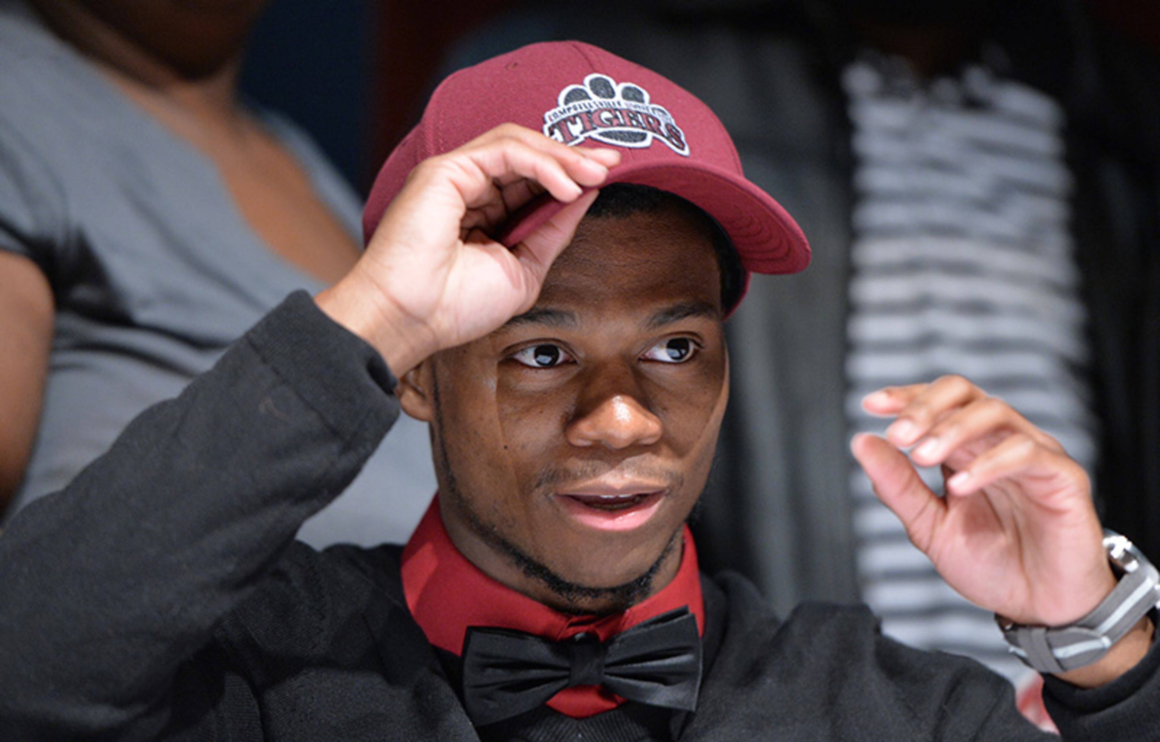 Demetrius Smith picks Campbellsville putting his hat during signing day at Tucker High School.