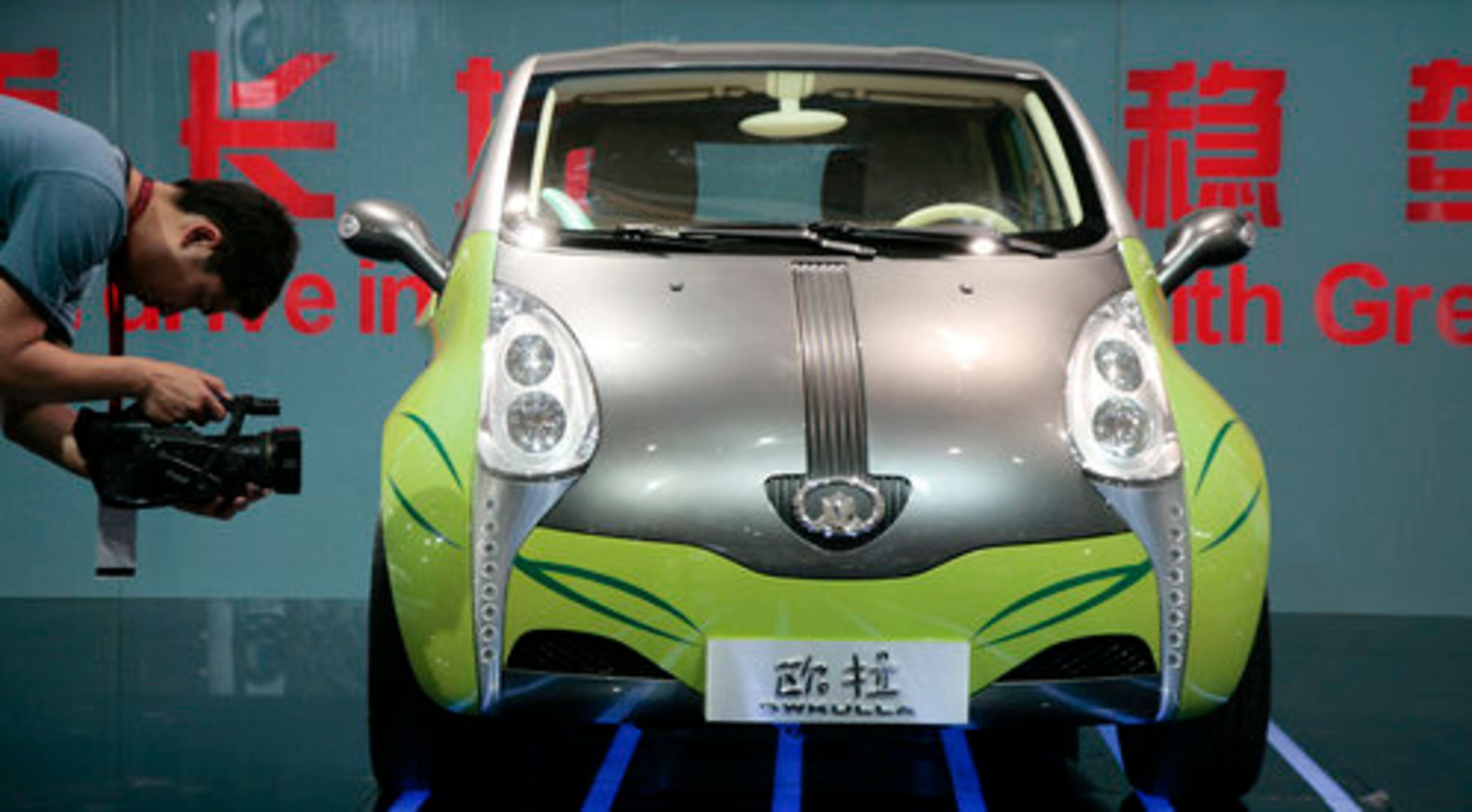 A journalist records video of a Great Wall Motor Co. Gwkulla.