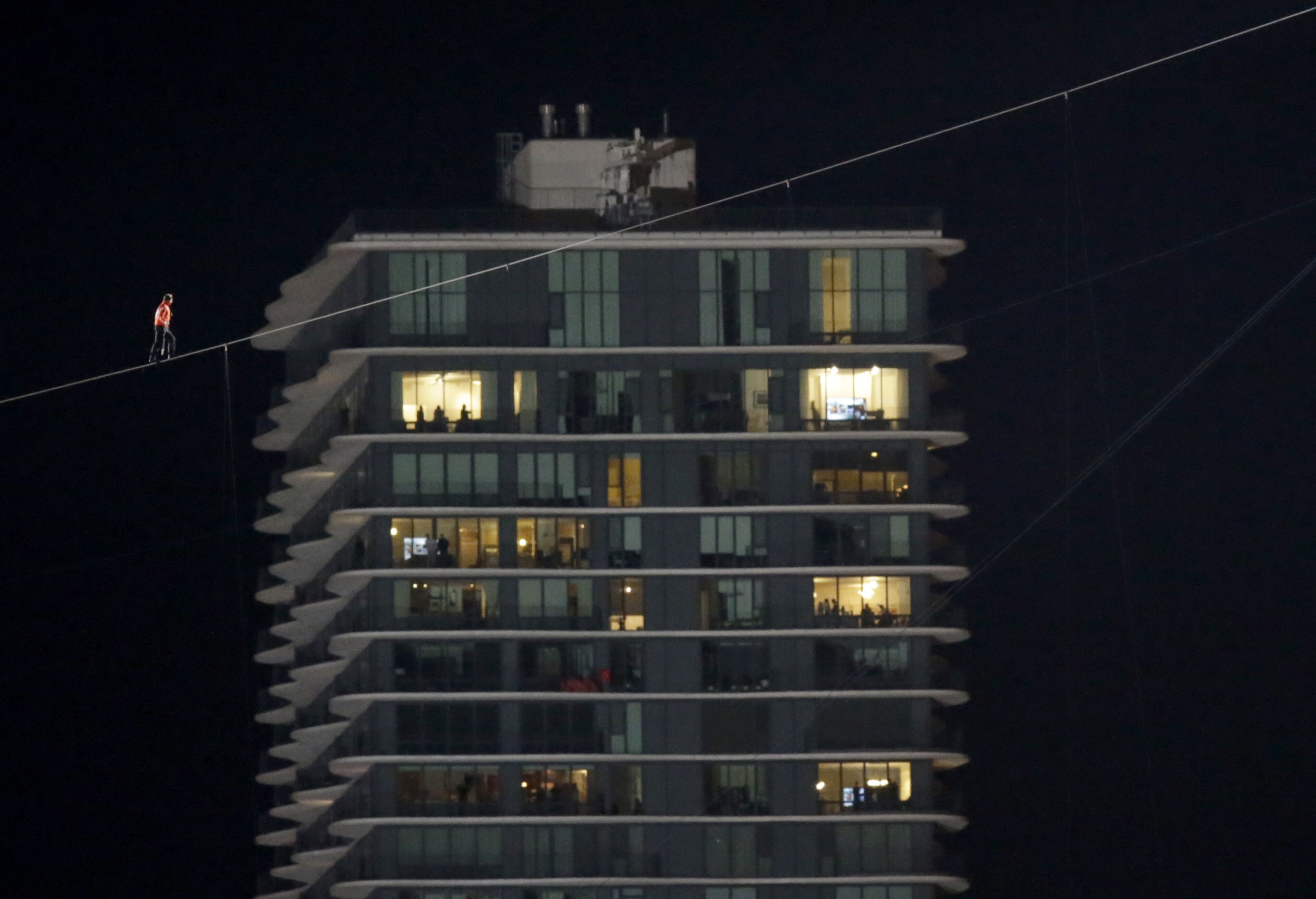 Daredevil Nik Wallenda makes his tightrope walk uphill at a 15-degree angle, from the Marina City west tower across the Chicago River to the top of the Leo Burnett Building, past the Aqua Building, background, Sunday, Nov. 2, 2014, in Chicago. (AP Photo/Charles Rex Arbogast)