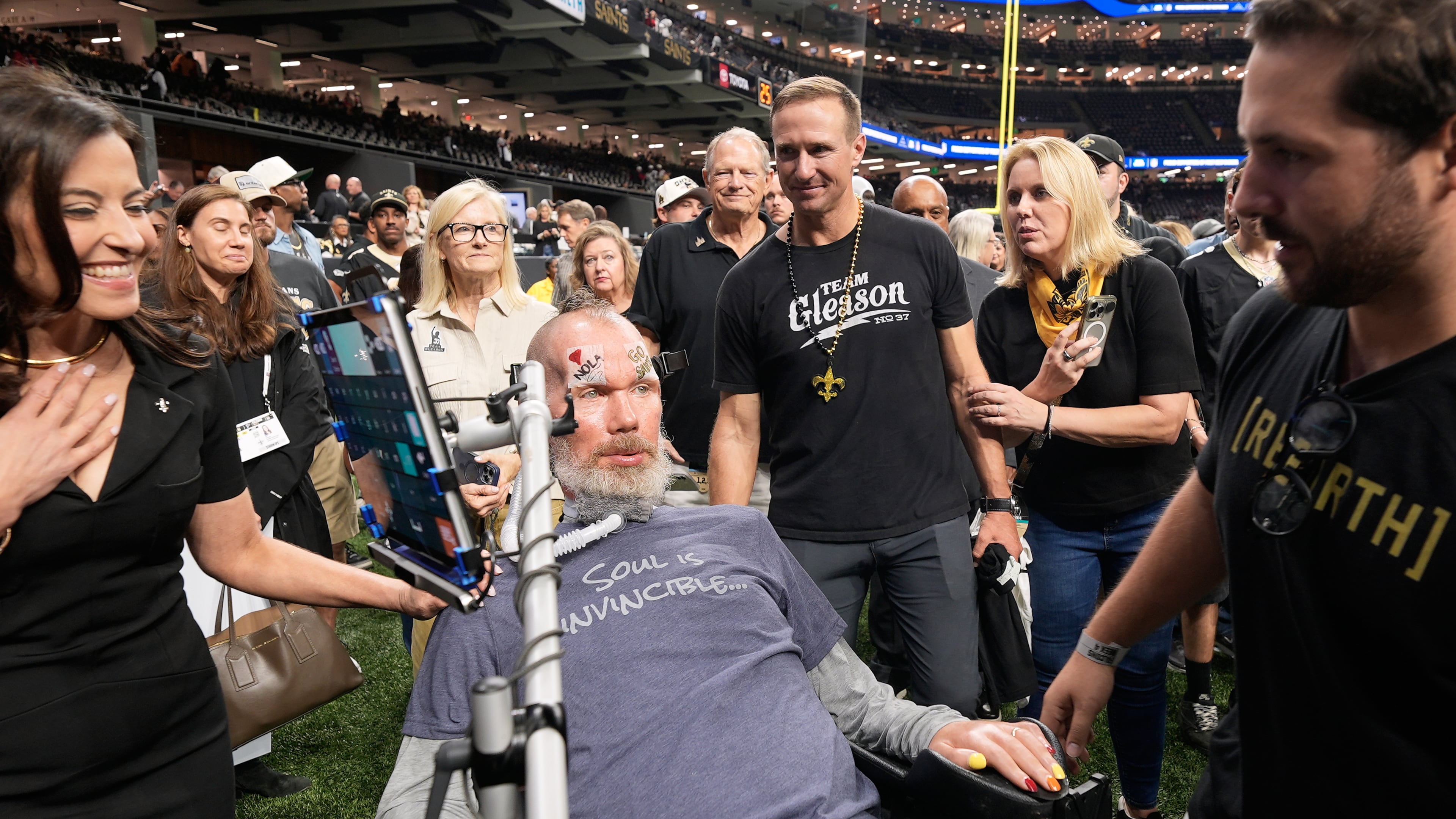 Former New Orleans Saints quarterback Drew Brees, middle right, approaches former player Steve Gleason, middle foreground, before an NFL football game between the Saints and the Atlanta Falcons in New Orleans, Monday, Oct. 5, 2026. (AP Photo/Gerald Herbert)