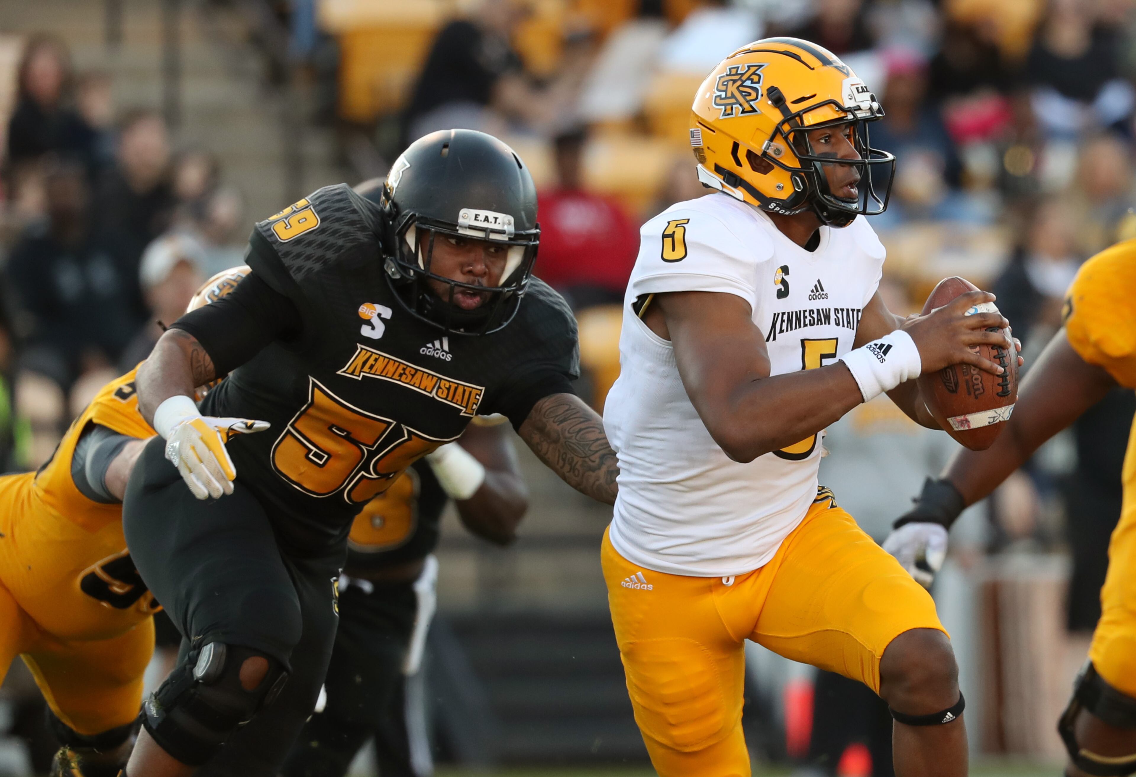 March 22, 2019 - Kennesaw, Ga: Kennesaw State Owls quarterback Tommy Bryant (5) runs away from the pressure from defensive lineman Desmond Johnson (59) during the KSU spring football game at Fifth Third Bank Stadium Friday, March 22, 2019 in Kennesaw, Ga.. (JASON GETZ/SPECIAL TO THE AJC)