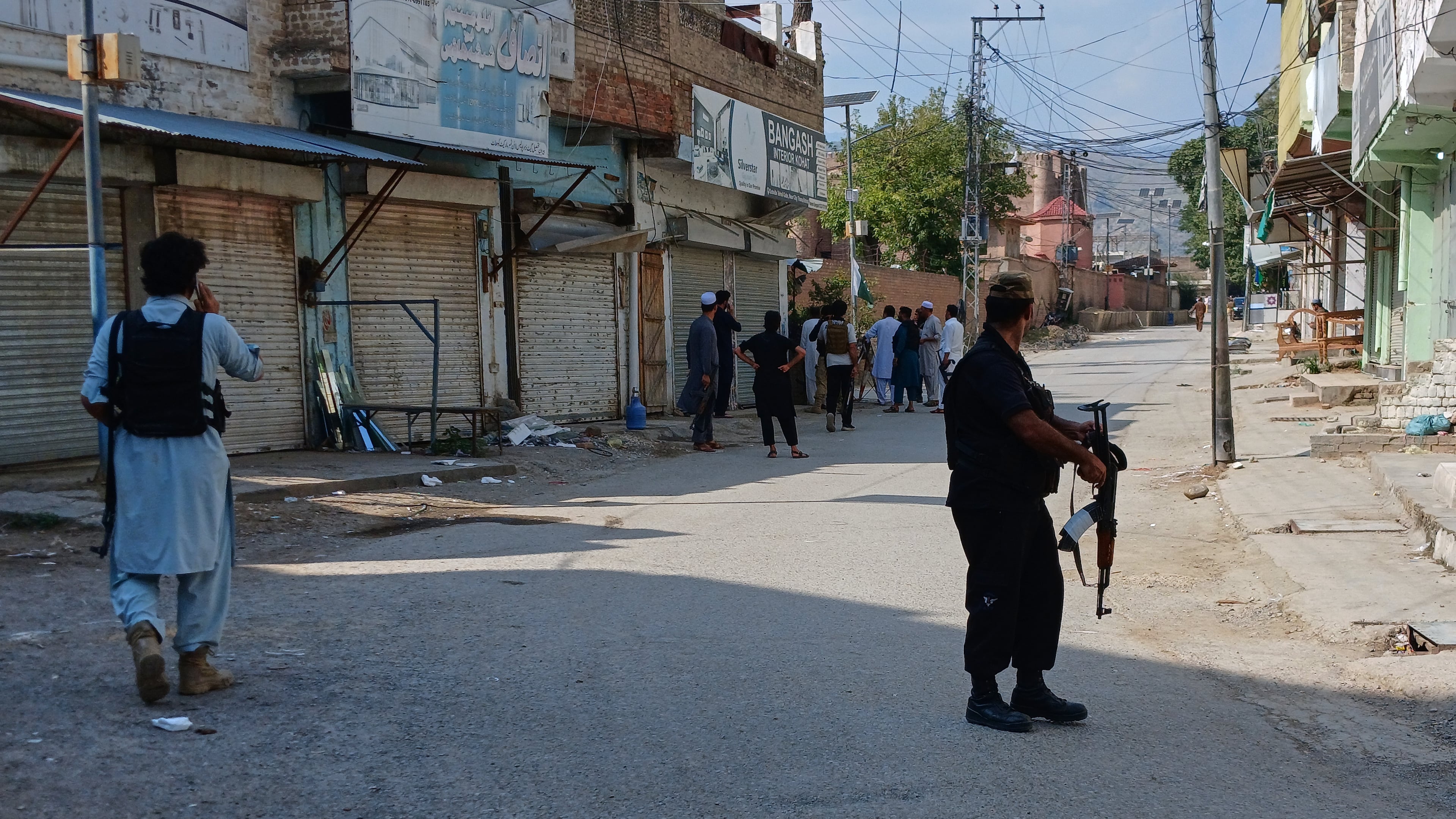 In this photo taken with a smartphone, police officers secure a road leading to the site of a powerful bomb at a mosque in Kohat, Pakistan, Friday, Sept. 18, 2026. (AP Photo/B.S. Gillani)
