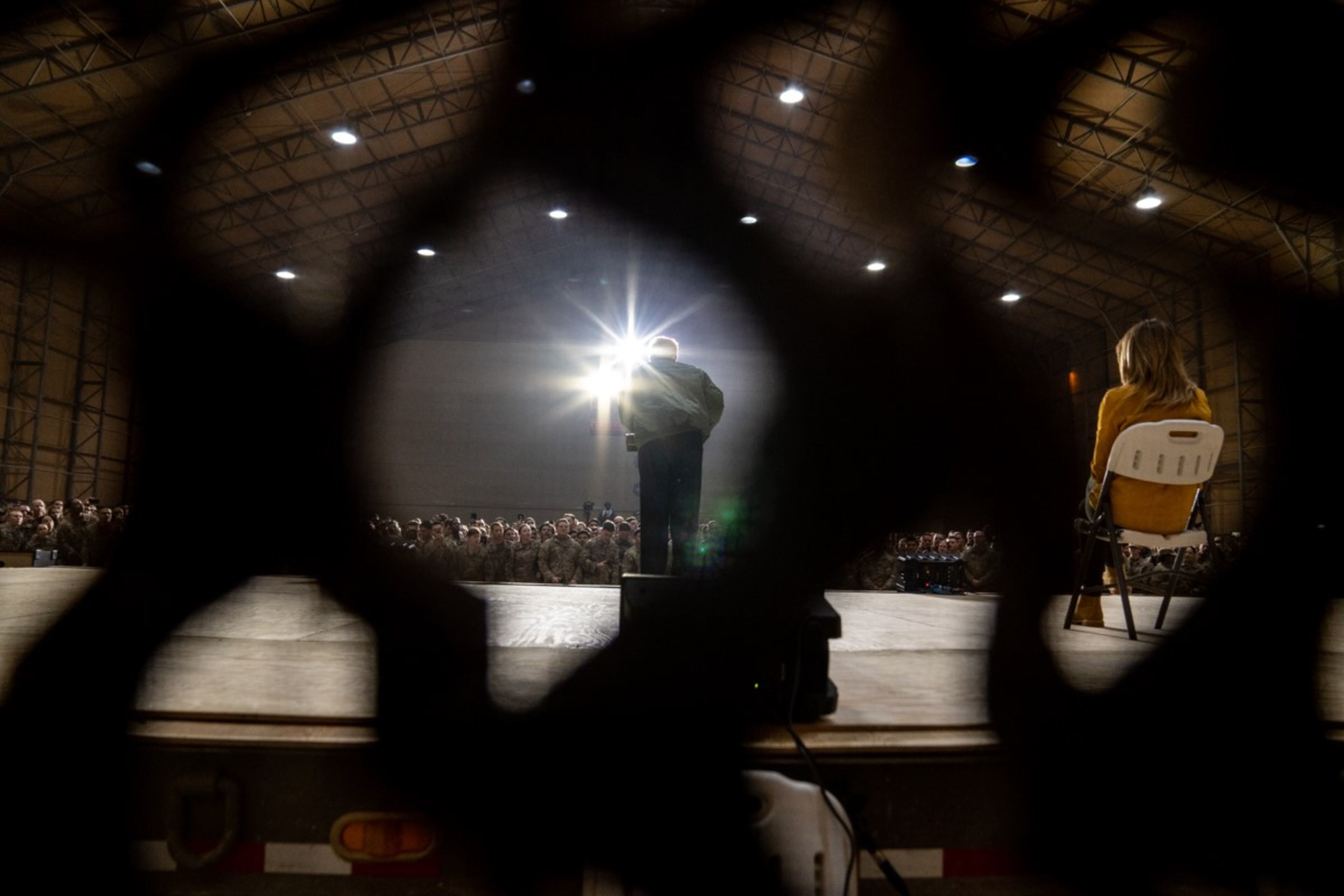 President Donald J. Trump, joined by First Lady Melania Trump, is seen through camouflage netting as he addresses his remarks to U.S. troops Wednesday, December 26, 2018, at the Al-Asad Airbase in Iraq.