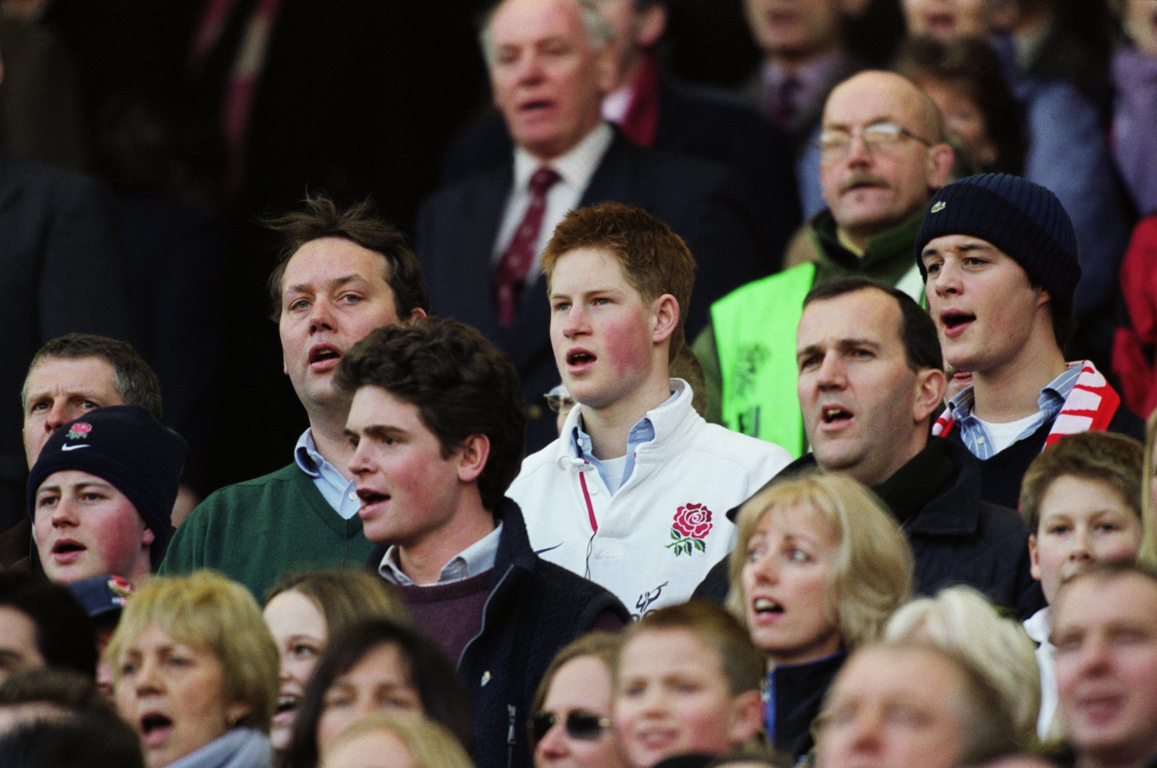 In this Feb. 16, 2002, image, Prince Harry (center) sings the national anthem before the Lloyds TSB Six Nations Championship match between England and Ireland played at Twickenham, in London. England won the match 45-11.