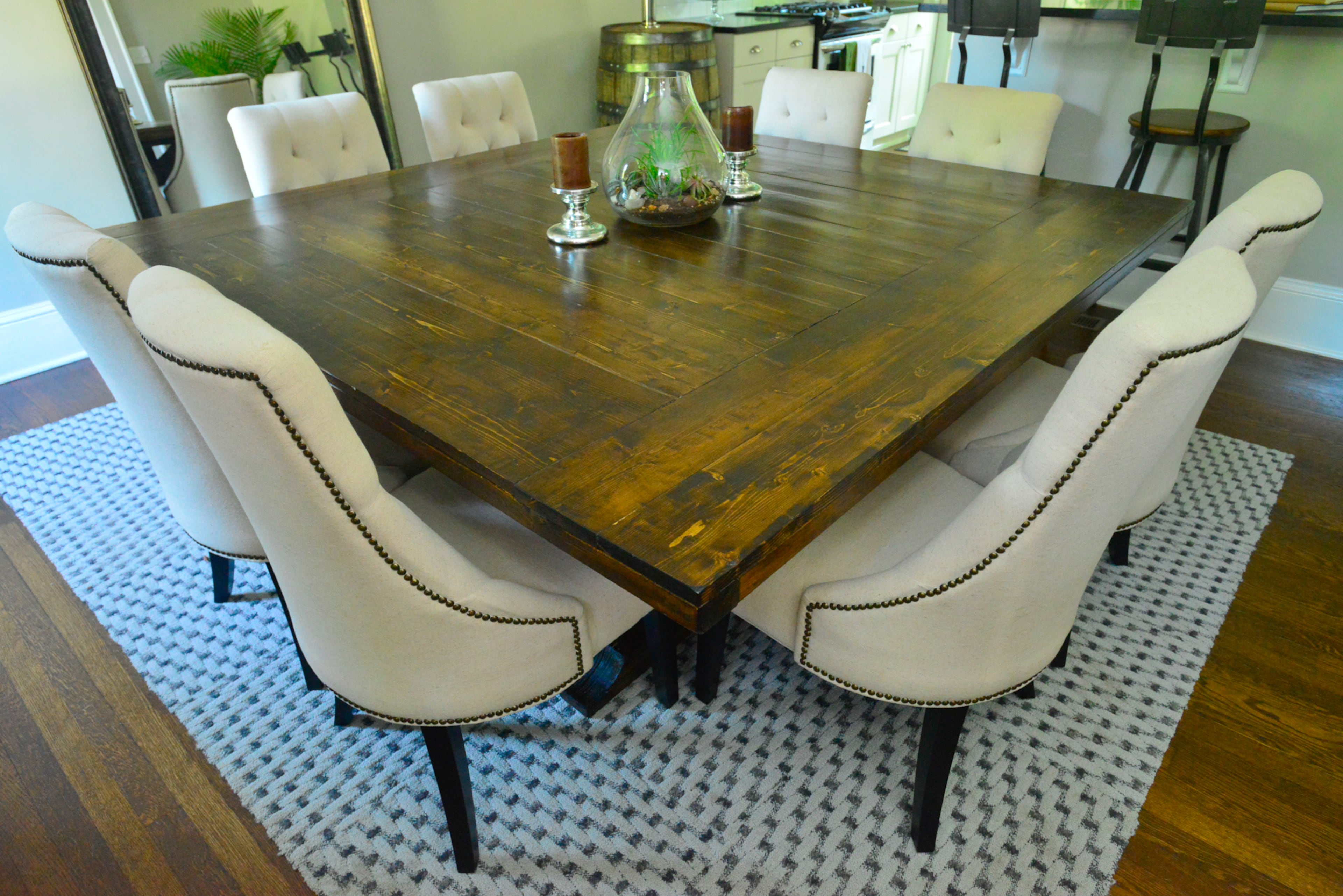Homeowner Franklin Johnson built the 6-by-6-foot wood dining table in the Atlanta home, which can seat up to 10 people. Upholstered chairs from World Market surround the table, and the rug is from Floor & Decor.