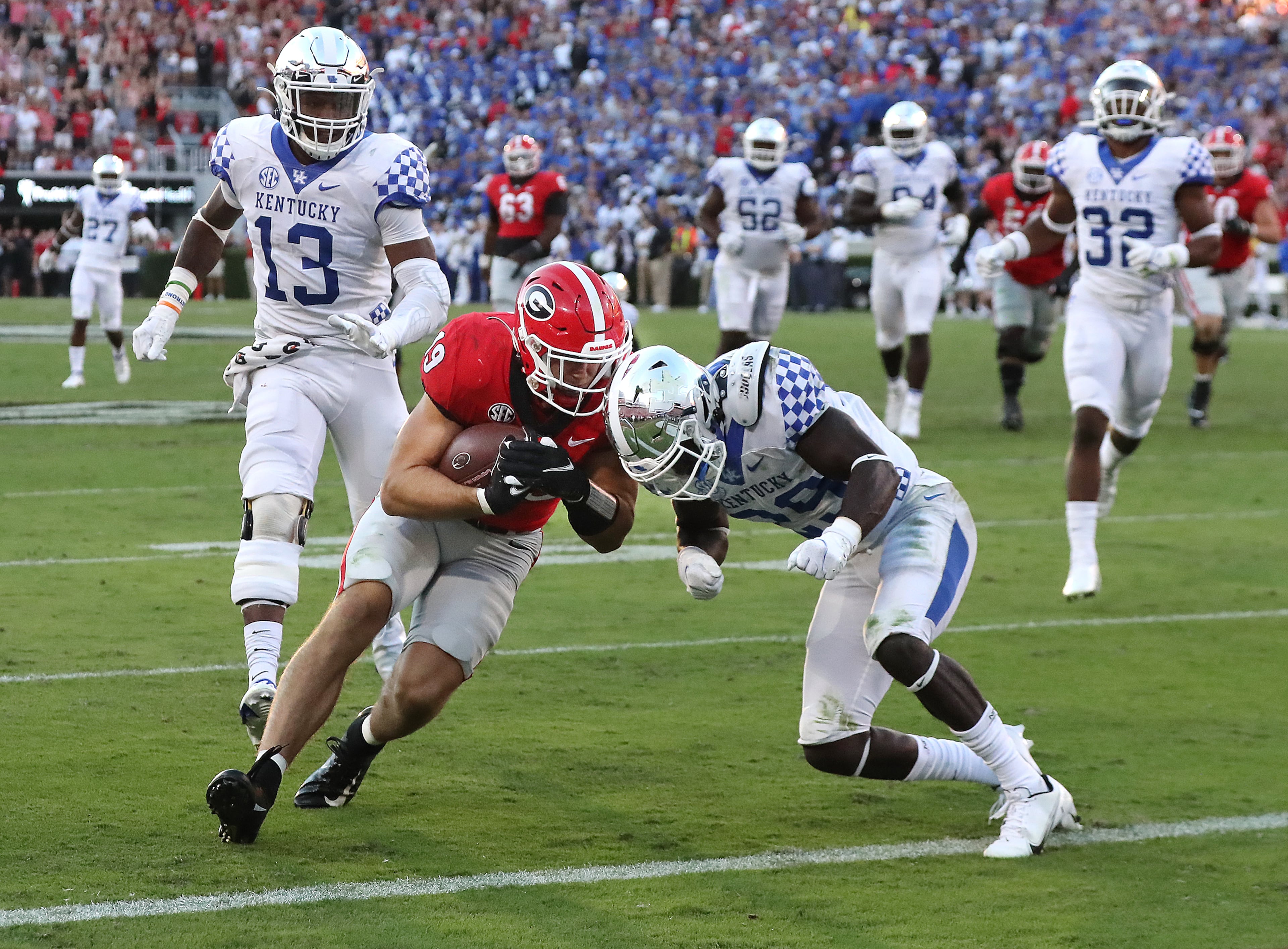 Georgia tight end Brock Bowers gets into the end zone for the touchdown past Kentucky defendera JJ. Weaver (left) and Yusuf Corker (right) to take a 30-7 lead during the 4th quarter in a NCAA college football game on Saturday, Oct. 16, 2021, in Athens. “Curtis Compton / Curtis.Compton@ajc.com”