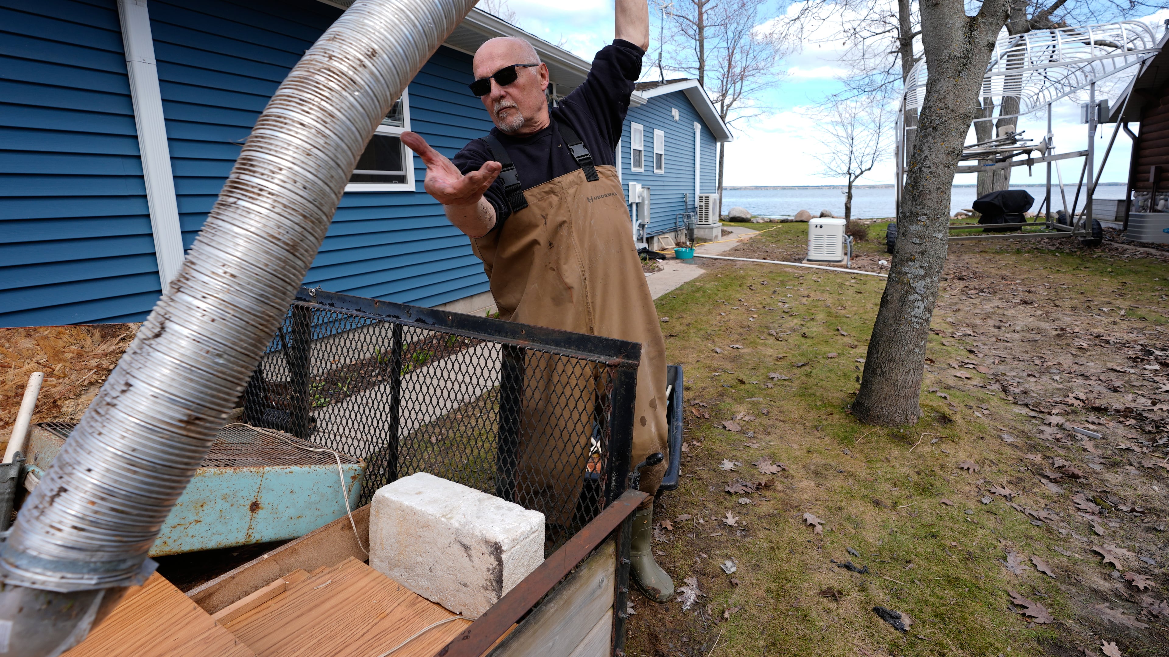 Tom Peterman cleans up outside his home from recent floods at Black Lake on Wednesday, April 29, 2026, in Grant Township, Mich. (AP Photo/Paul Sancya)
