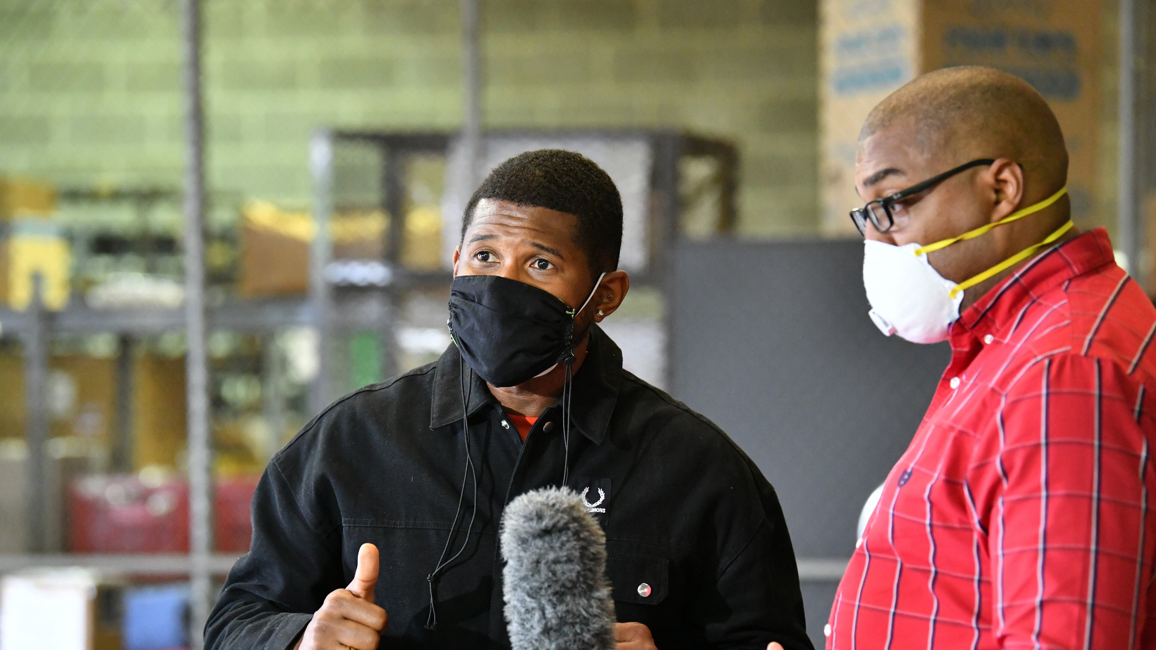 Usher and Clayton County Schools Superintendent Morcease Beasley speak at a May press conference at which the singer announced a donation of 350 plant-based meals for residents of the south metro community. (Hyosub Shin / Hyosub.Shin@ajc.com)