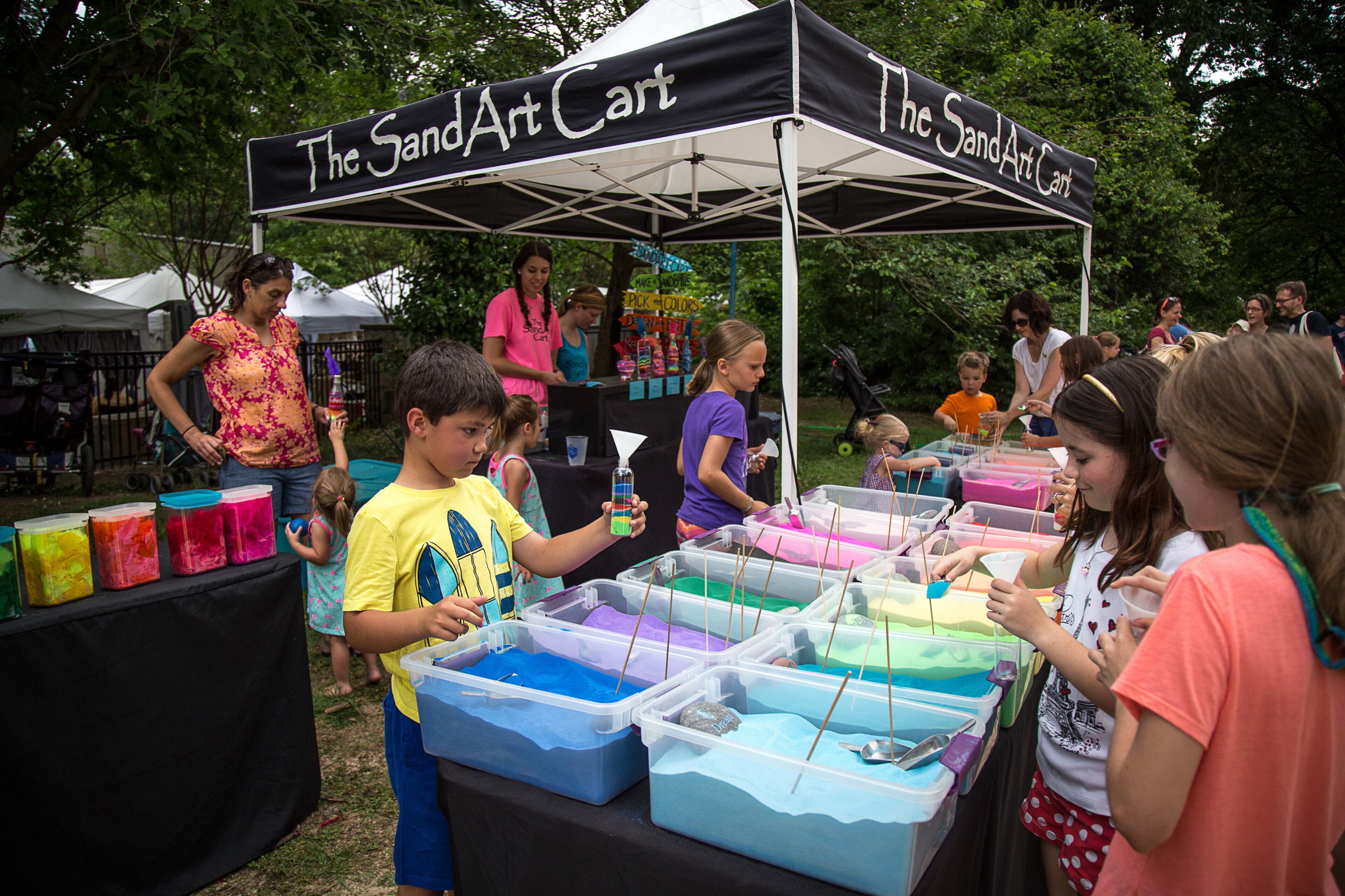 Kids load colorful sand into a bottle at the Kidsfest area during the Summerfest in Atlanta on Saturday, June 4, 2016. STEVE SCHAEFER / SPECIAL TO THE AJC