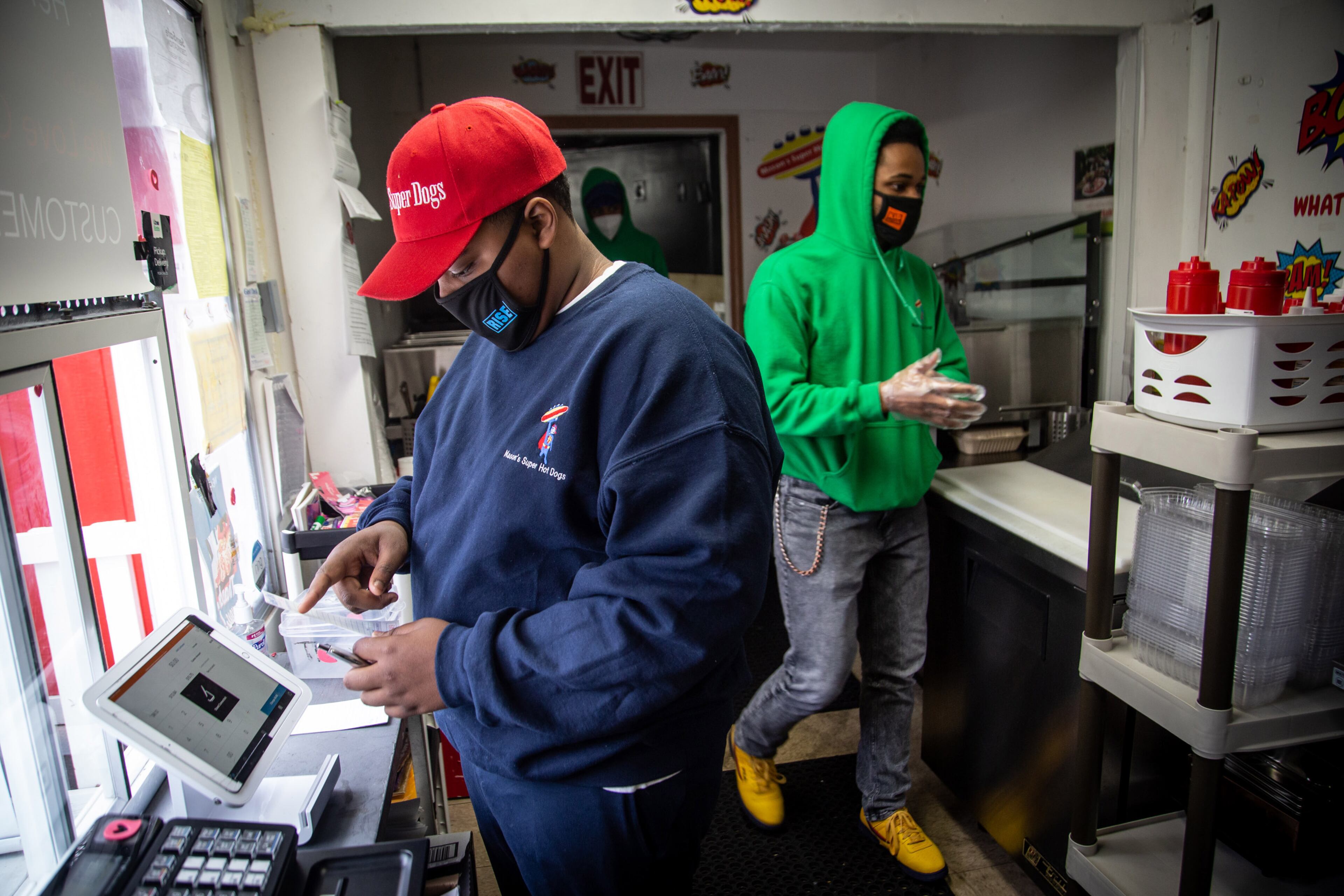 Young entrepreneur Mason Wright (left) and Ayden Whitely put together a food order at Mason's Super Dogs restaurant in Stonecrest. STEVE SCHAEFER FOR THE AJC