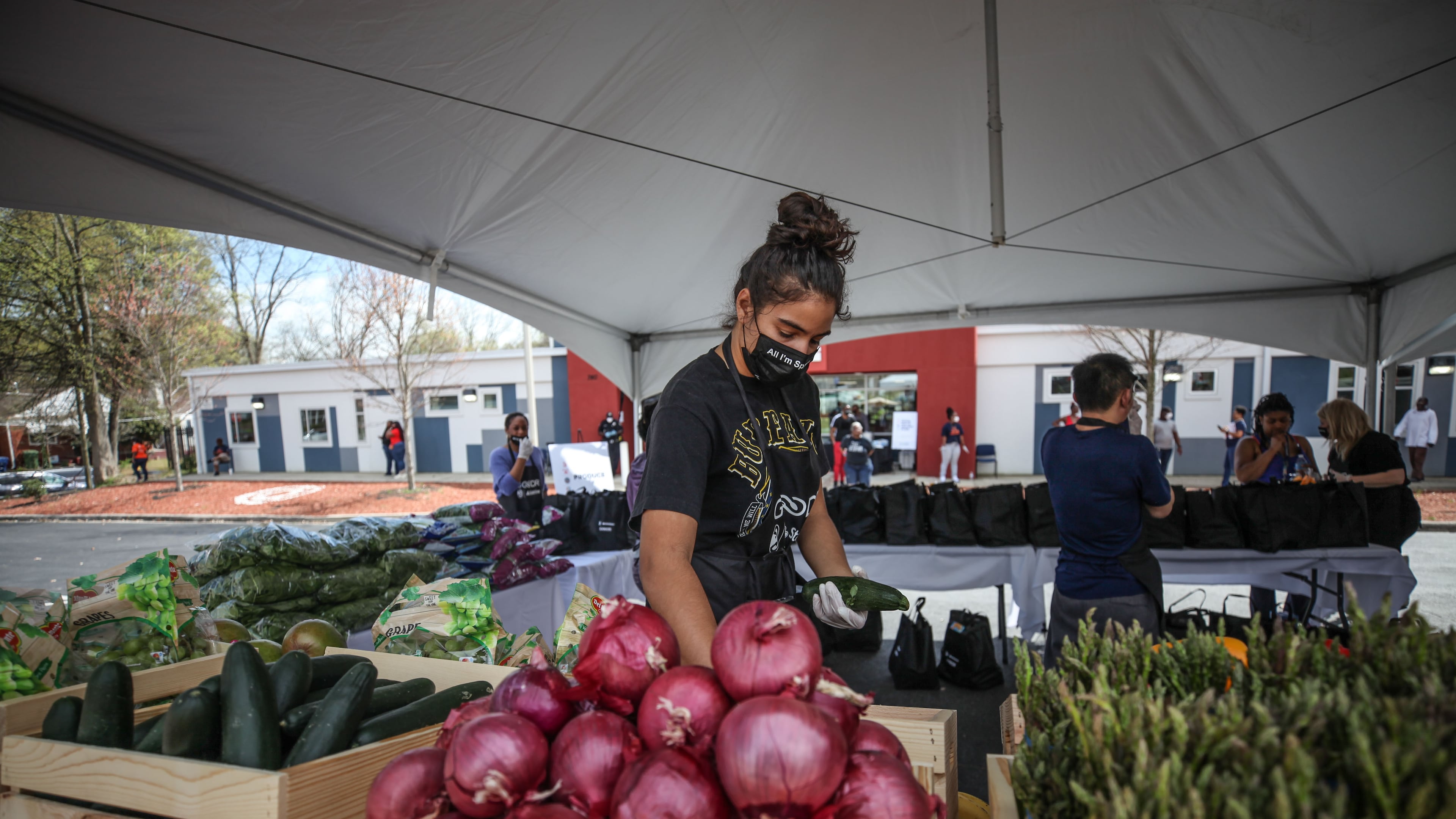A woman grabs fresh produce at the first of five pop-up grocery store locations. BRANDEN CAMP/SPECIAL