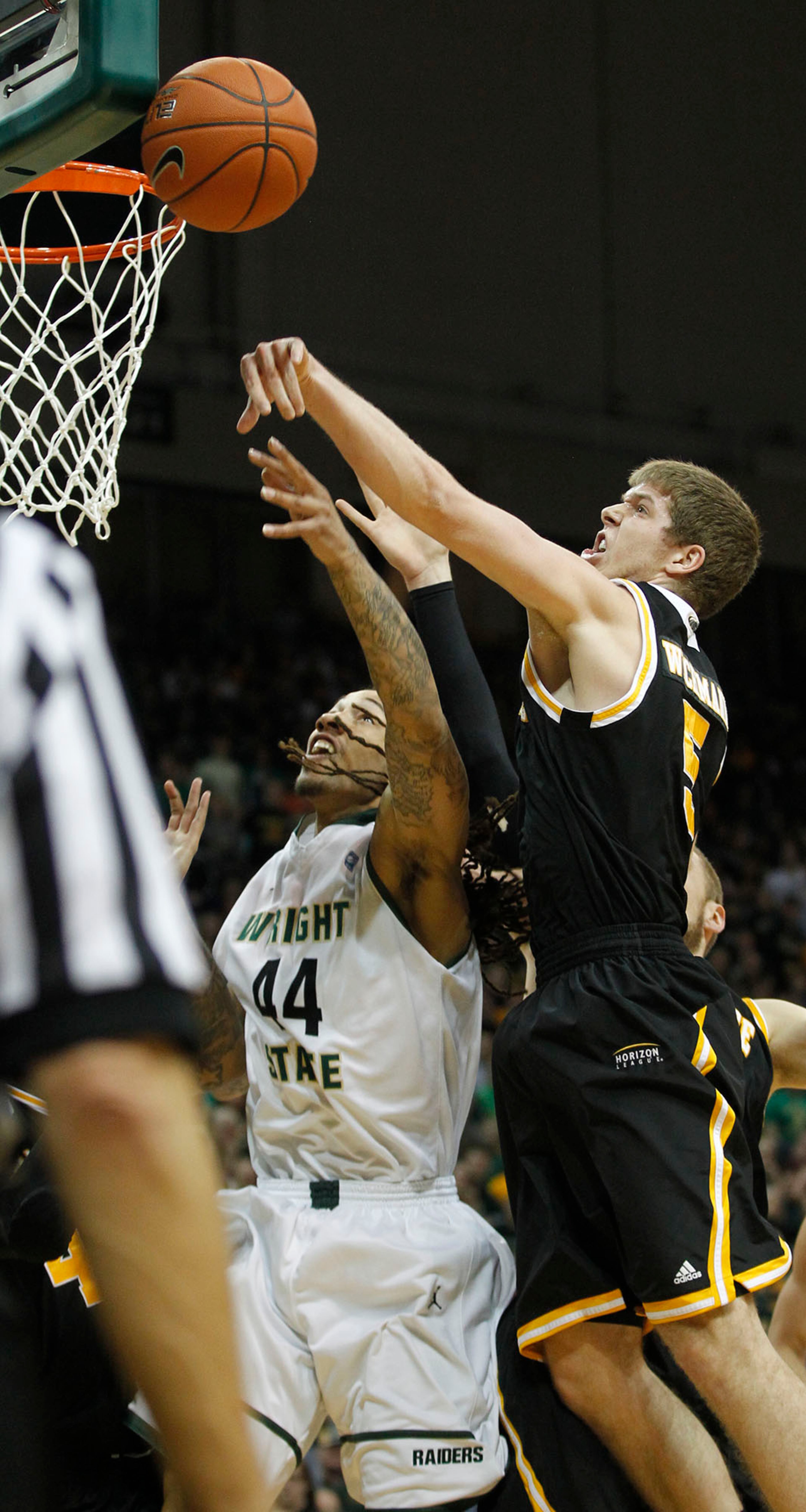 Milwaukee's Cody Whichmann slapped away this shot by Wright State's Tavares Sledge during the first half as the Raiders hosted the Panthers for the Horizon League Championship. Score at the half is Raiders 33, Panthers 43. TY GREENLEES / STAFF
