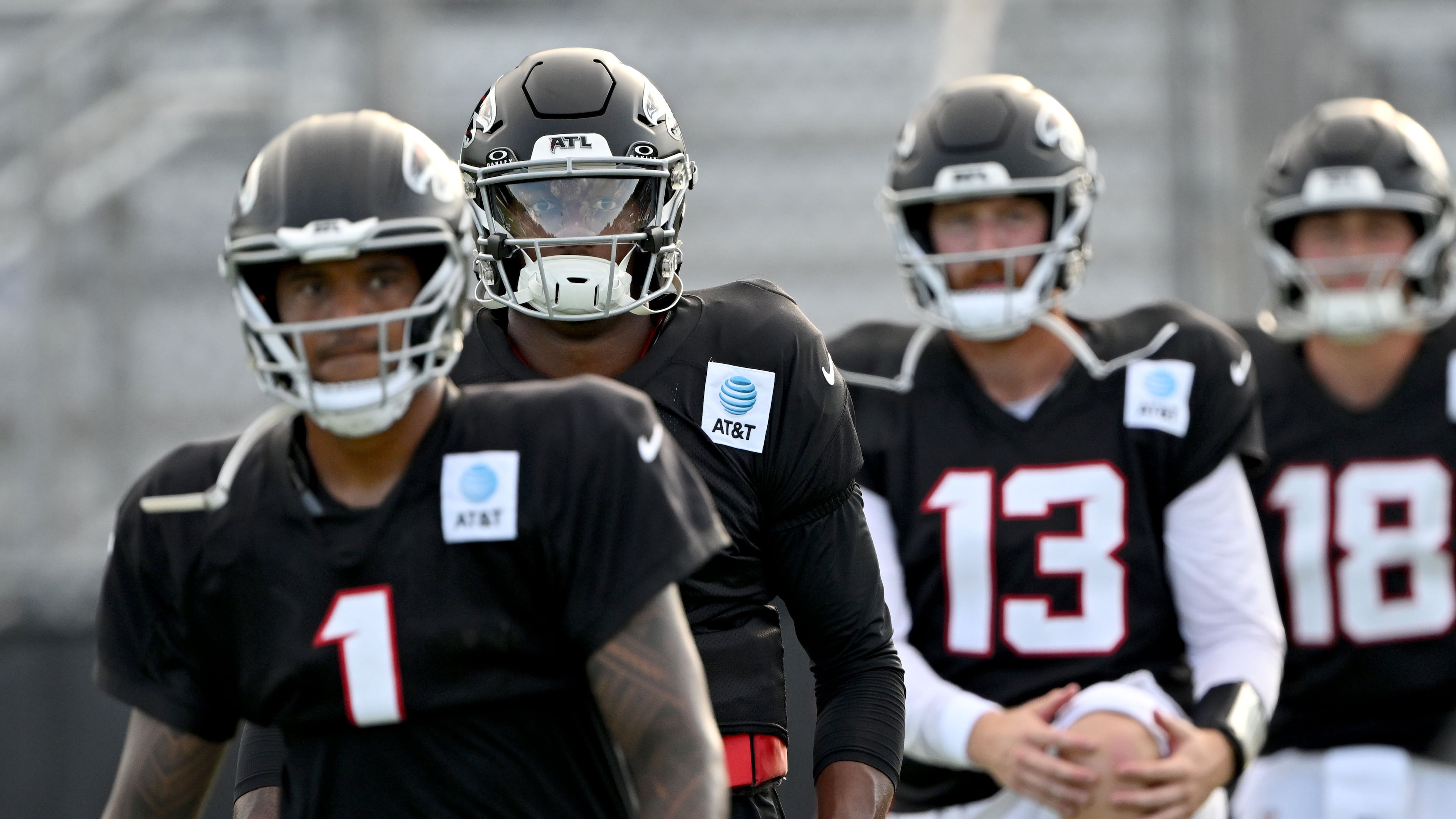 Atlanta Falcons quarterbacks, from left, Tua Tagovailoa (left), Michael Penix Jr. (second from left), Cooper Rush (second from right) and Jack Strand (right) warm up during the Atlanta Falcons' Saturday Night Lights practice at Lanier High School on Saturday, Aug. 8, 2026, in Sugar Hill. (Hyosub Shin/AJC)