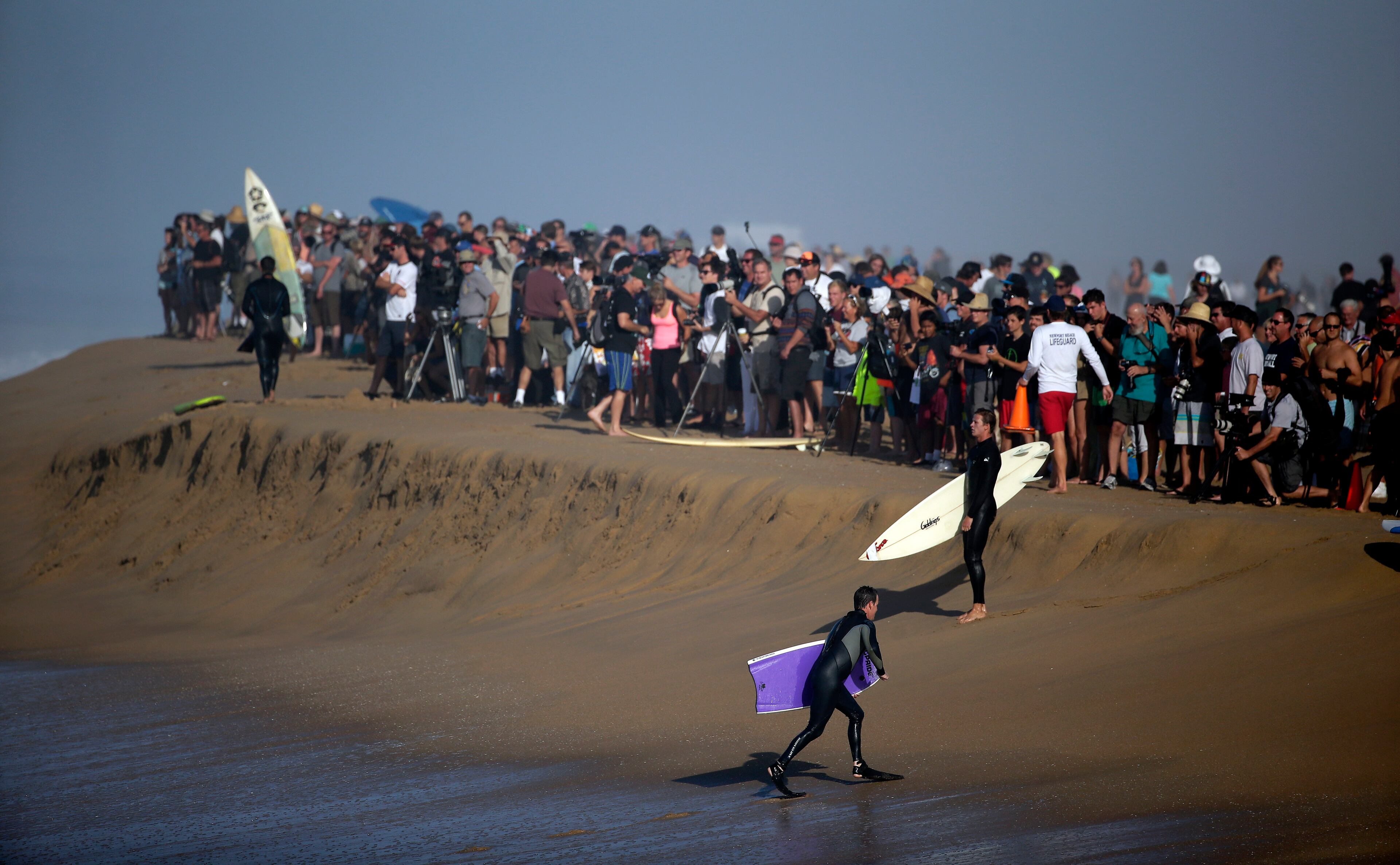 A large crowd gathers to watch surfers and body surfer ride waves at the wedge on Wednesday, Aug. 27, 2014 in Newport Beach, Calif. Beach goers experienced much higher than normal surf, brought on by Hurricane Marie spinning off the coast on Mexico. (AP Photo/Chris Carlson)