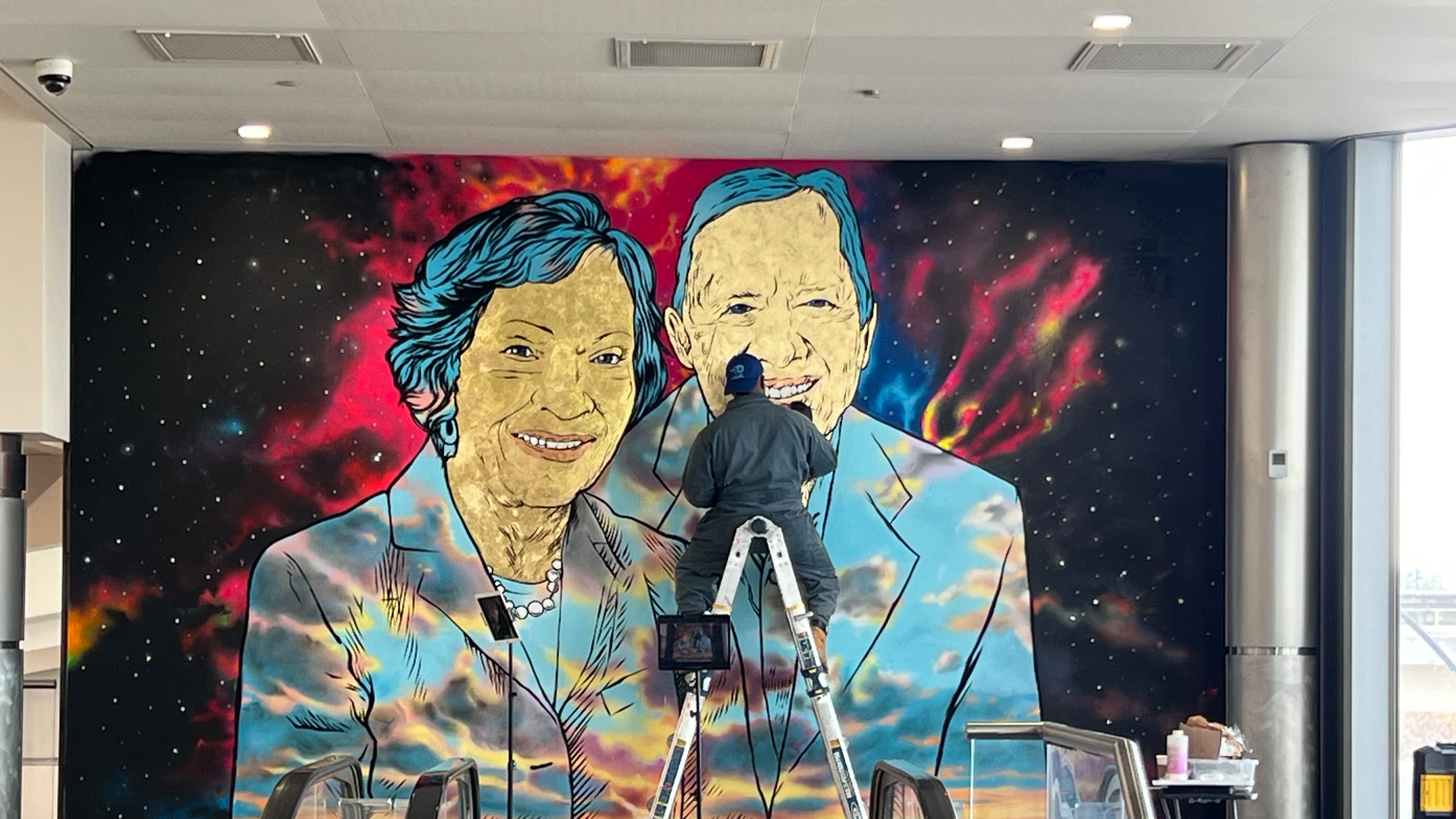 Artist Fabian Williams completes a mural of Jimmy and Rosalynn Carter at Hartsfield-Jackson Atlanta International Airport. (Kelly Yamanouchi/AJC)