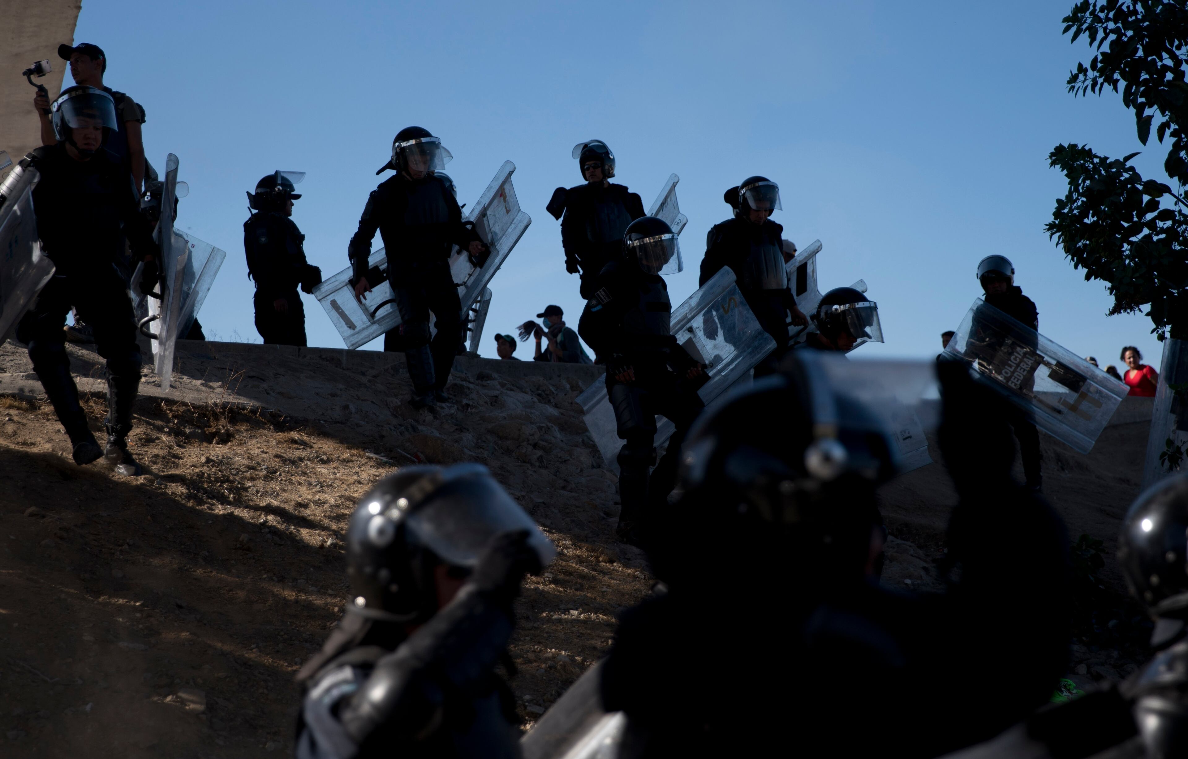 Mexican police spread out as they try to keep migrants from getting past the Chaparral border crossing in Tijuana, Mexico, Sunday, Nov. 25, 2018. The mayor of Tijuana has declared a humanitarian crisis in his border city and says that he has asked the United Nations for aid to deal with the approximately 5,000 Central American migrants who have arrived in the city. (AP Photo/Ramon Espinosa)