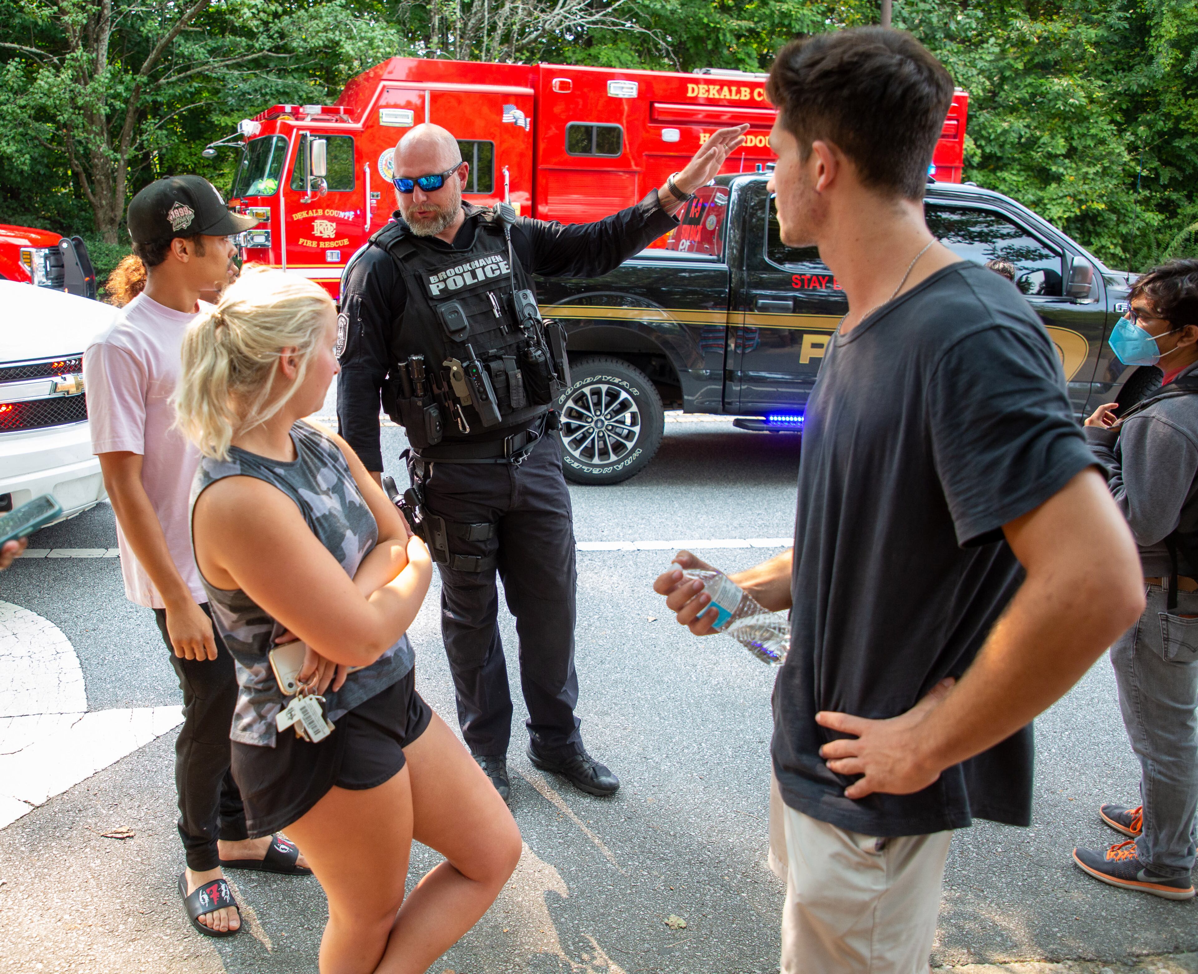 A police officer talks with the residents of the Arrive Perimeter apartment complex after an explosion damaged the building Sunday, September 12, 2021. STEVE SCHAEFER FOR THE ATLANTA JOURNAL-CONSTITUTION