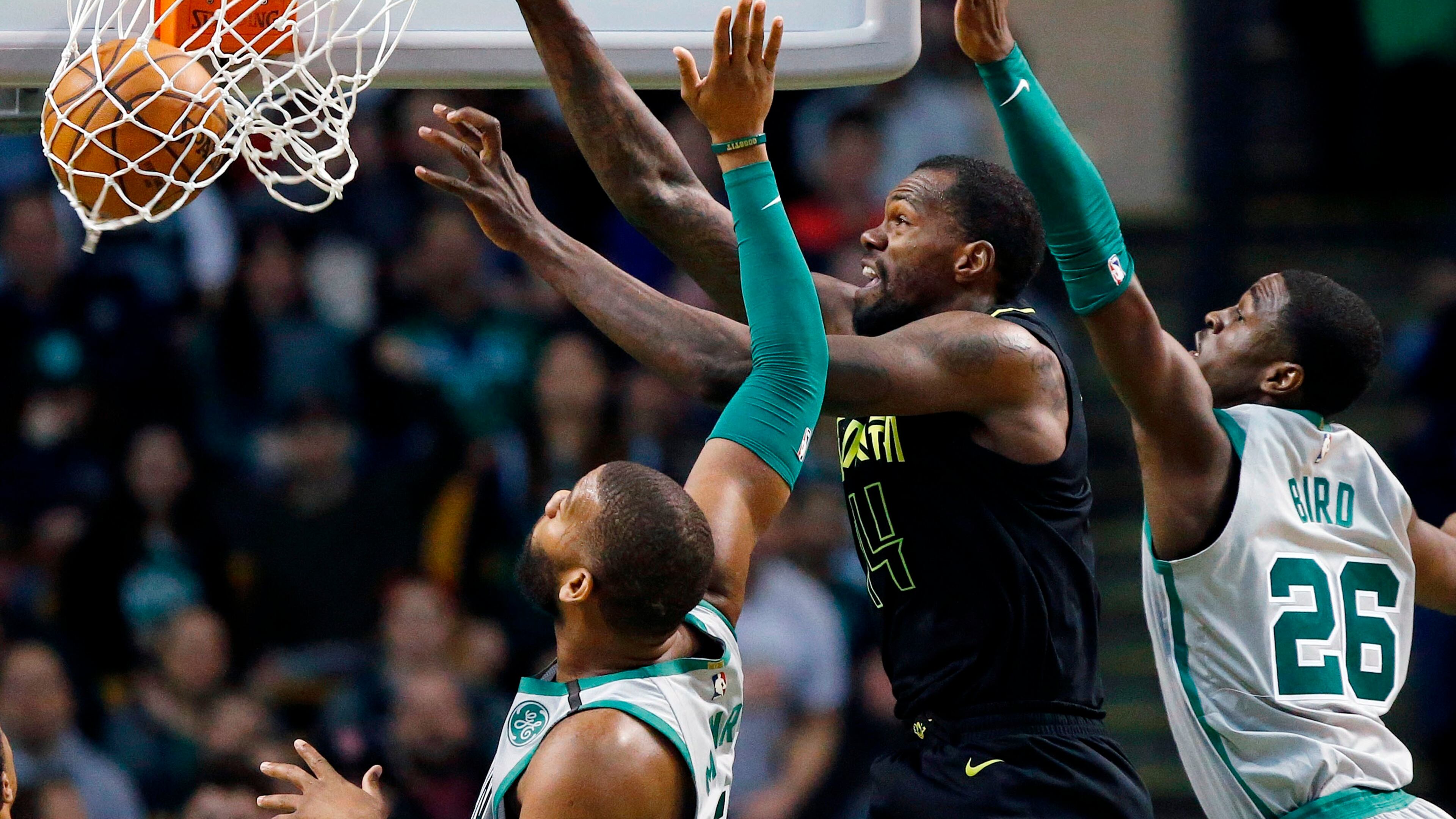 Atlanta Hawks' Dewayne Dedmon (14) dunks against Boston Celtics' Greg Monroe, left, and Jabari Bird (26) during the fourth quarter of an NBA basketball game in Boston, Sunday, April 8, 2018. The Hawks won 112-106. (AP Photo/Michael Dwyer)
