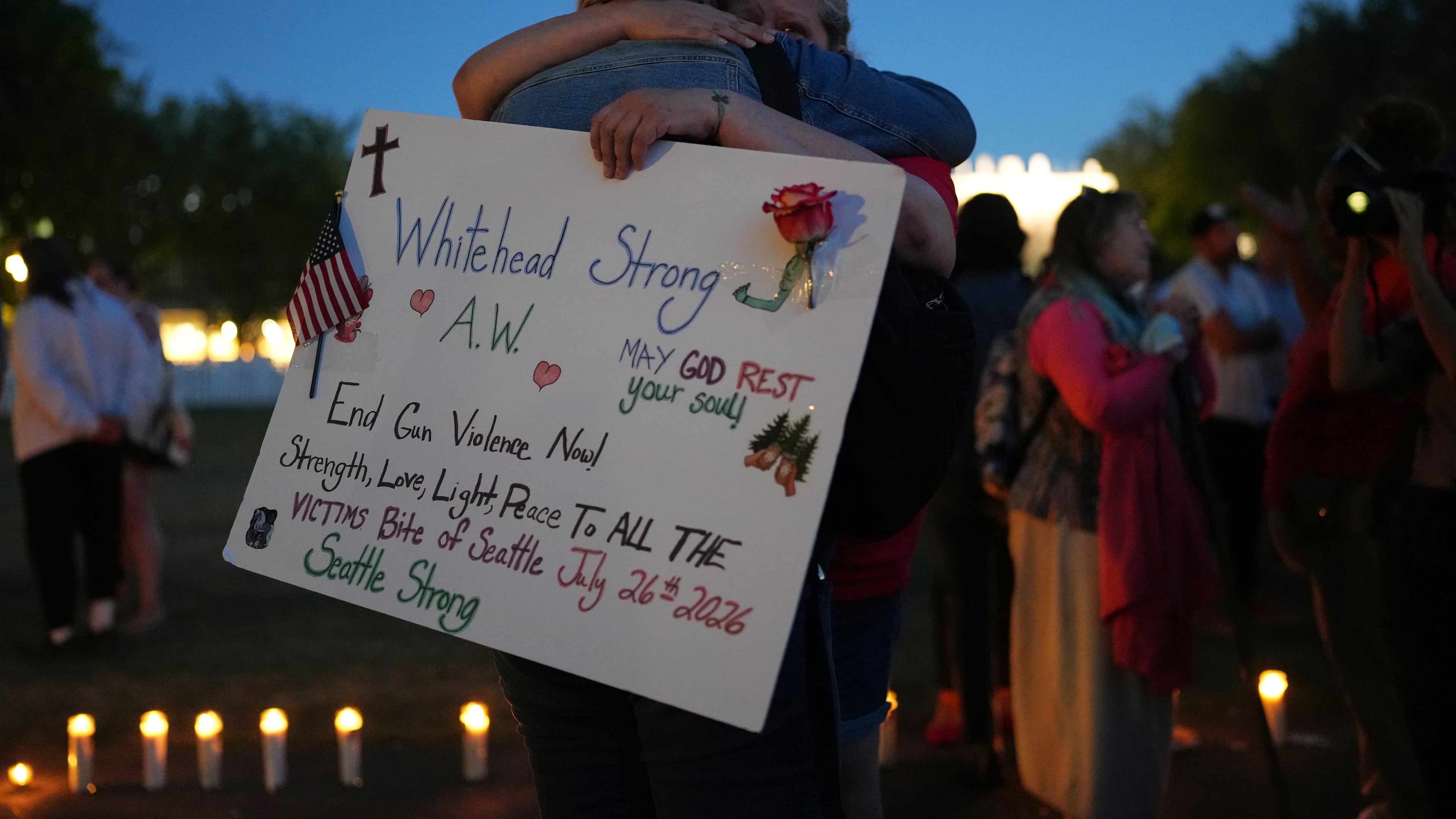 Michelle Whitehead, right, and her sister Judy Whitehead, left, both cousin of victim Ashley Whitehead, during the vigil for victims the day after a shooting at Seattle Center during the Bite of Seattle food festival, Monday, July 27, 2026, in Seattle. (AP Photo/Lindsey Wasson)