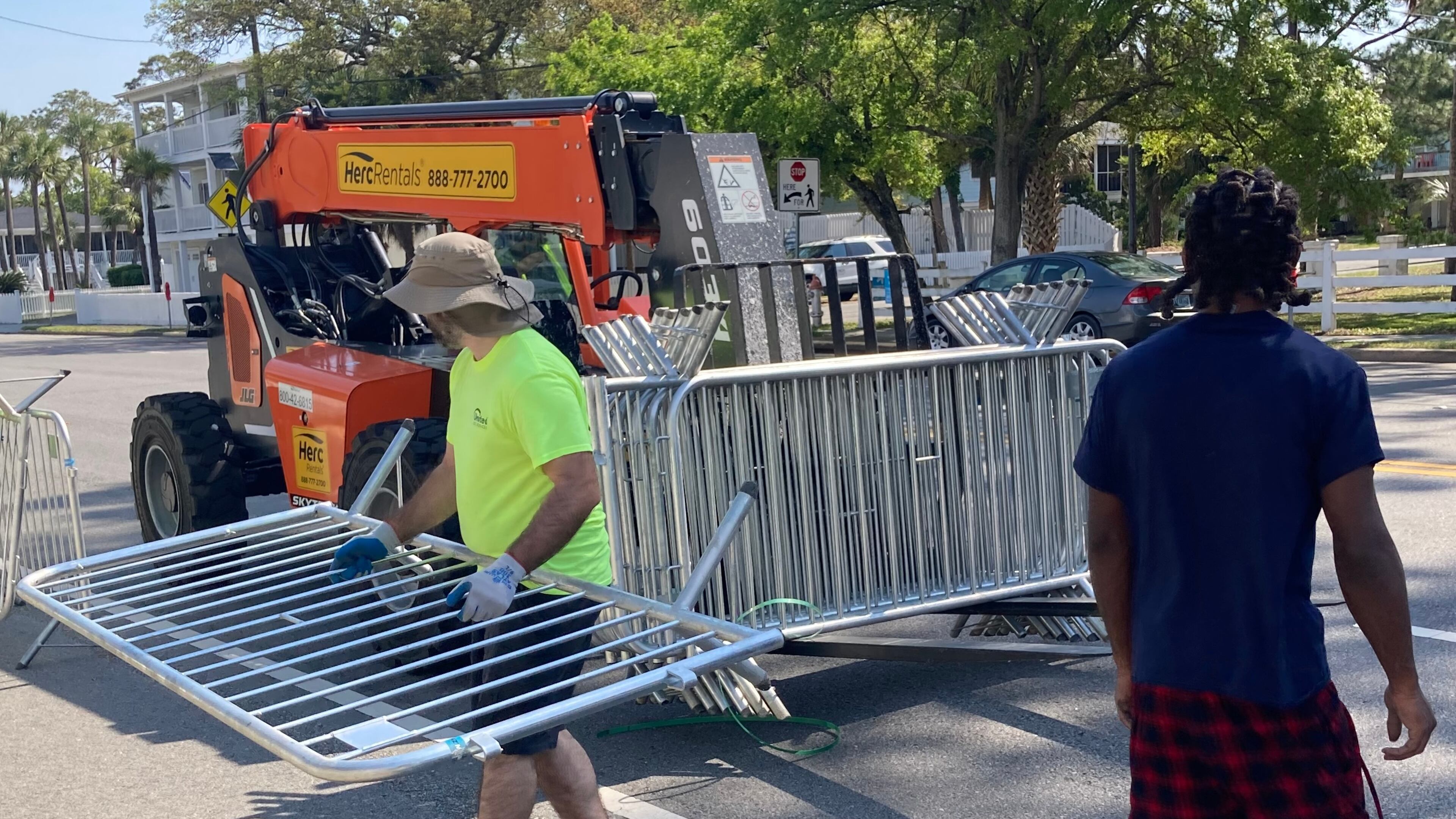 Tybee city workers place traffic barricades along U.S. 80 Tuesday in preparation for the Orange Crush beach party. (Adam Van Brimmer/AJC)
