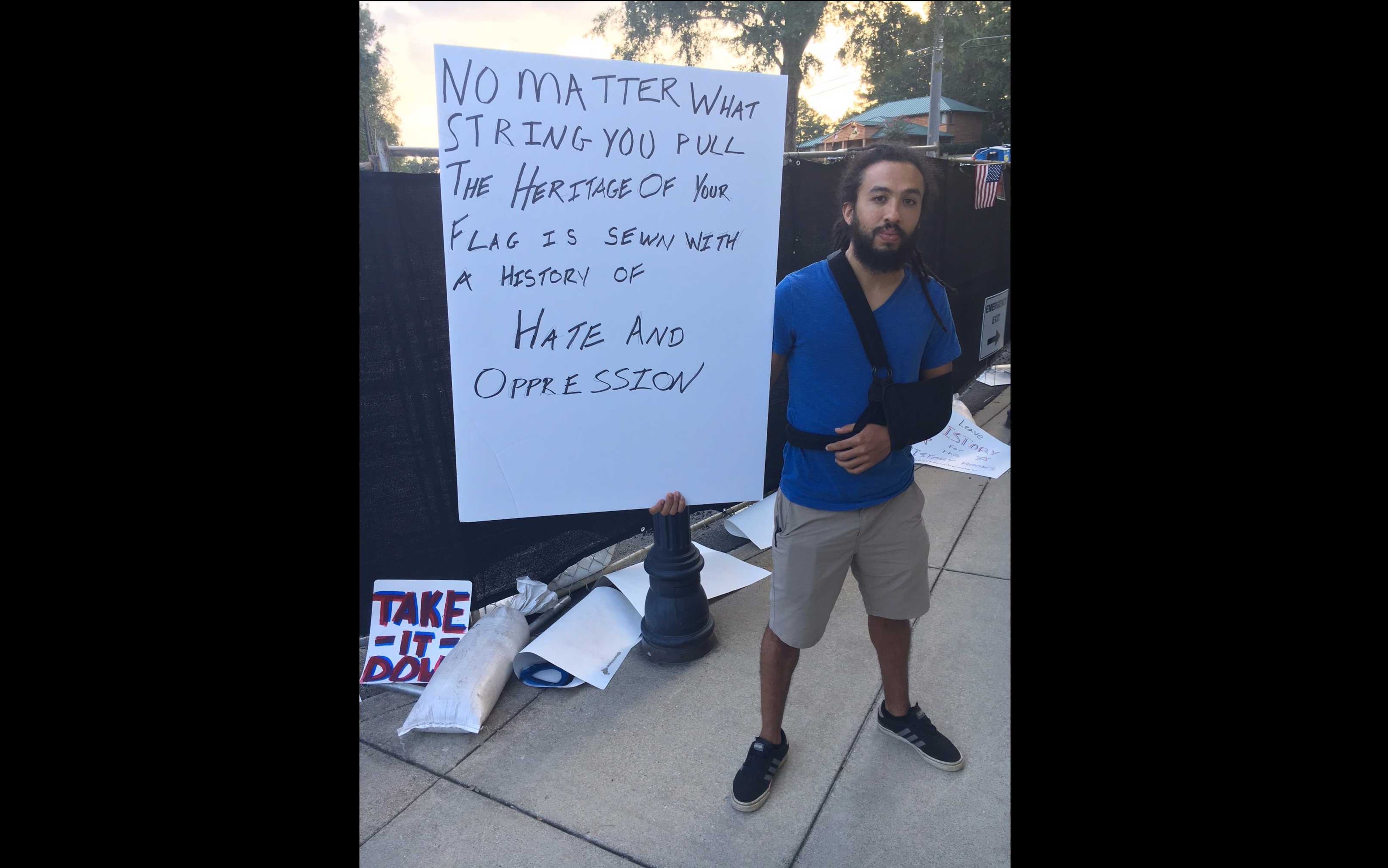 Daniel Dobry, 31, of Kennesaw, poses with the sign he marched with to city hall in favor of removing the city's Confederate flag downtown.