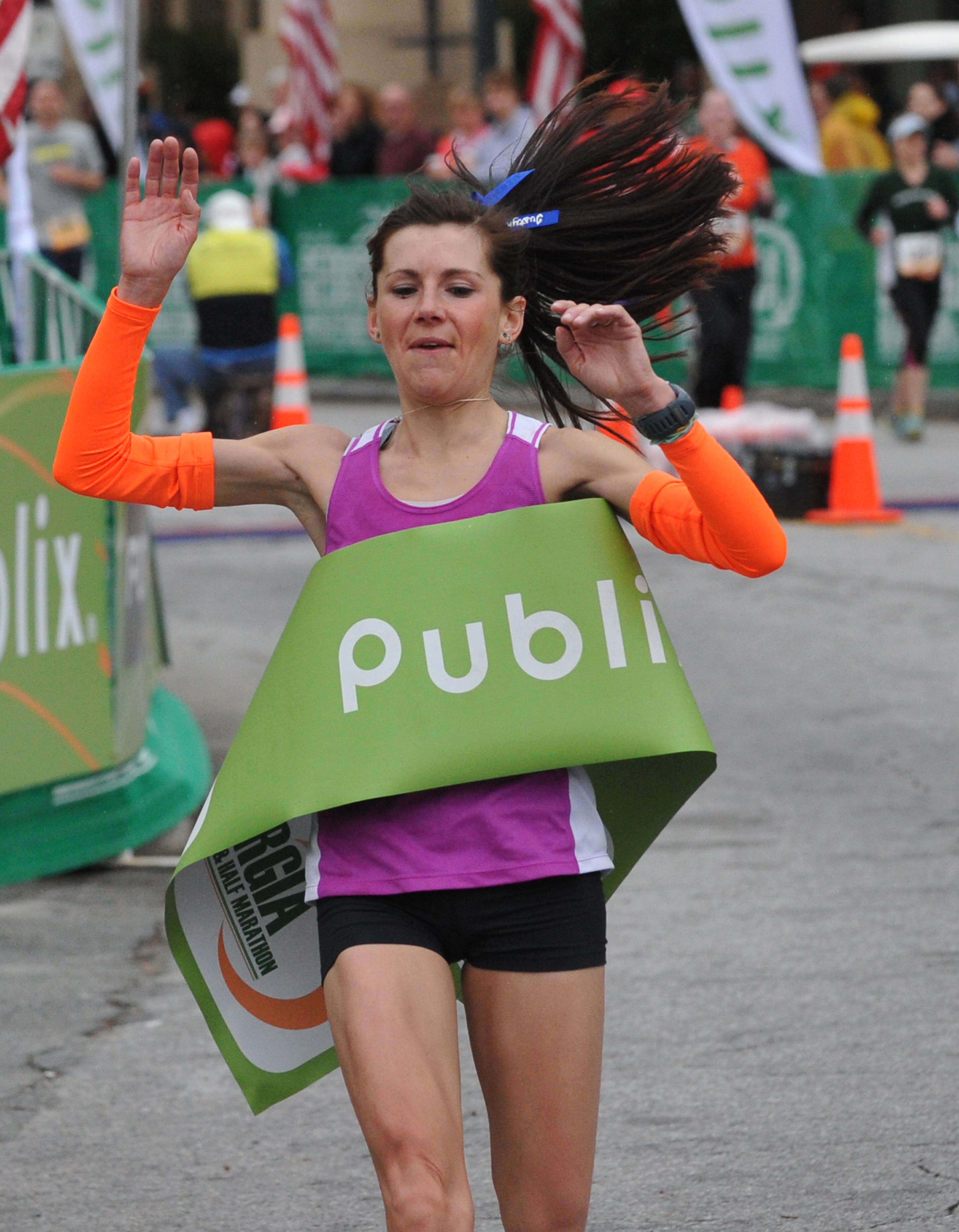 Justyna Mudy, of Rome, Ga., wins the female division as she crosses the finish line at Centennial Olympic Park with her time of 2:56:24 Sunday, March 23, 2014, in Atlanta. David Tulis / AJC Special