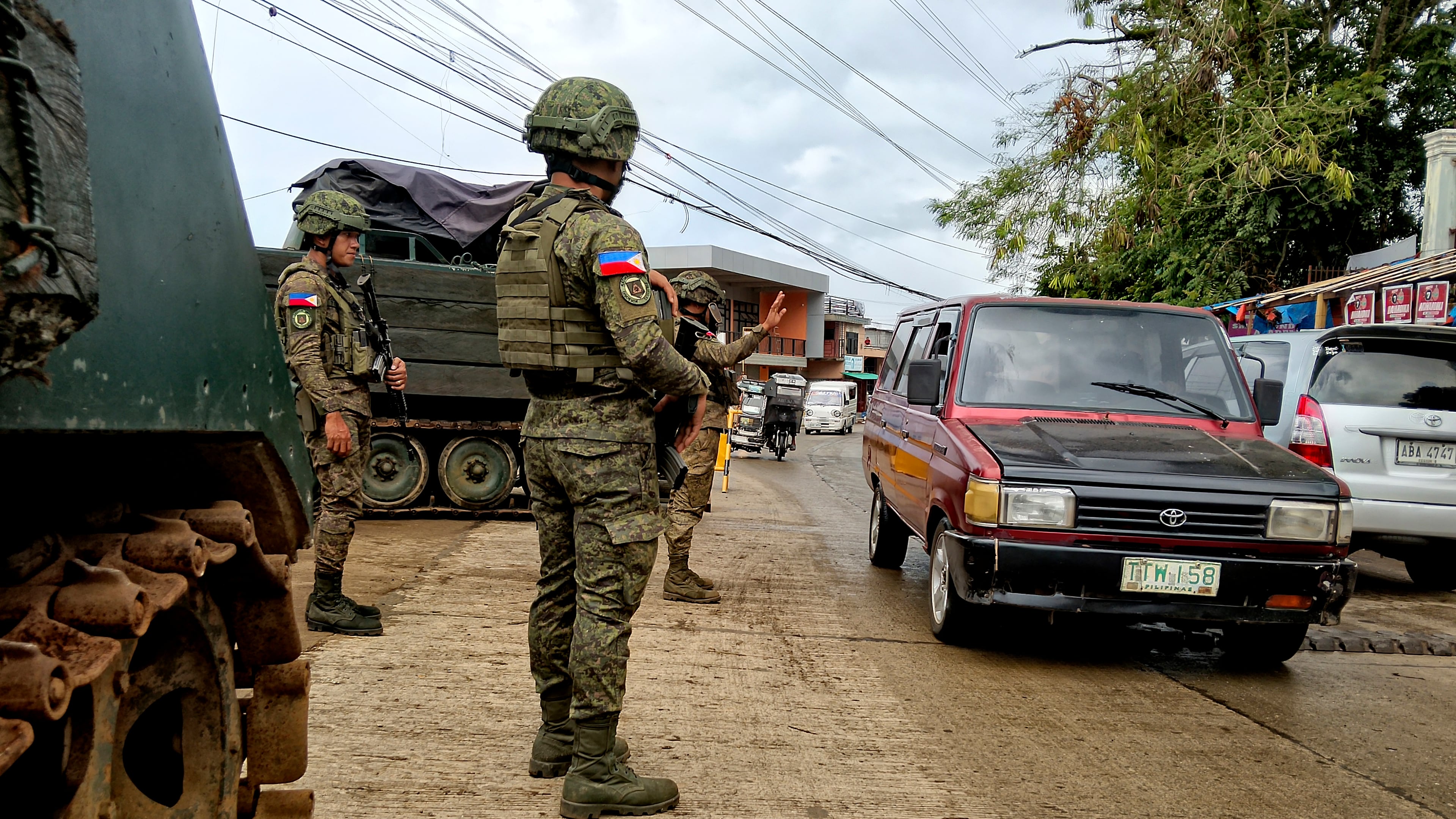 In this photo taken with a smartphone, Army soldiers check the flow of vehicular traffic along the highway in Marantao town, Lanao del Sur province, southern Philippines on Sunday Sept 13, 2026. (AP Photo/ Froilan Gallardo)