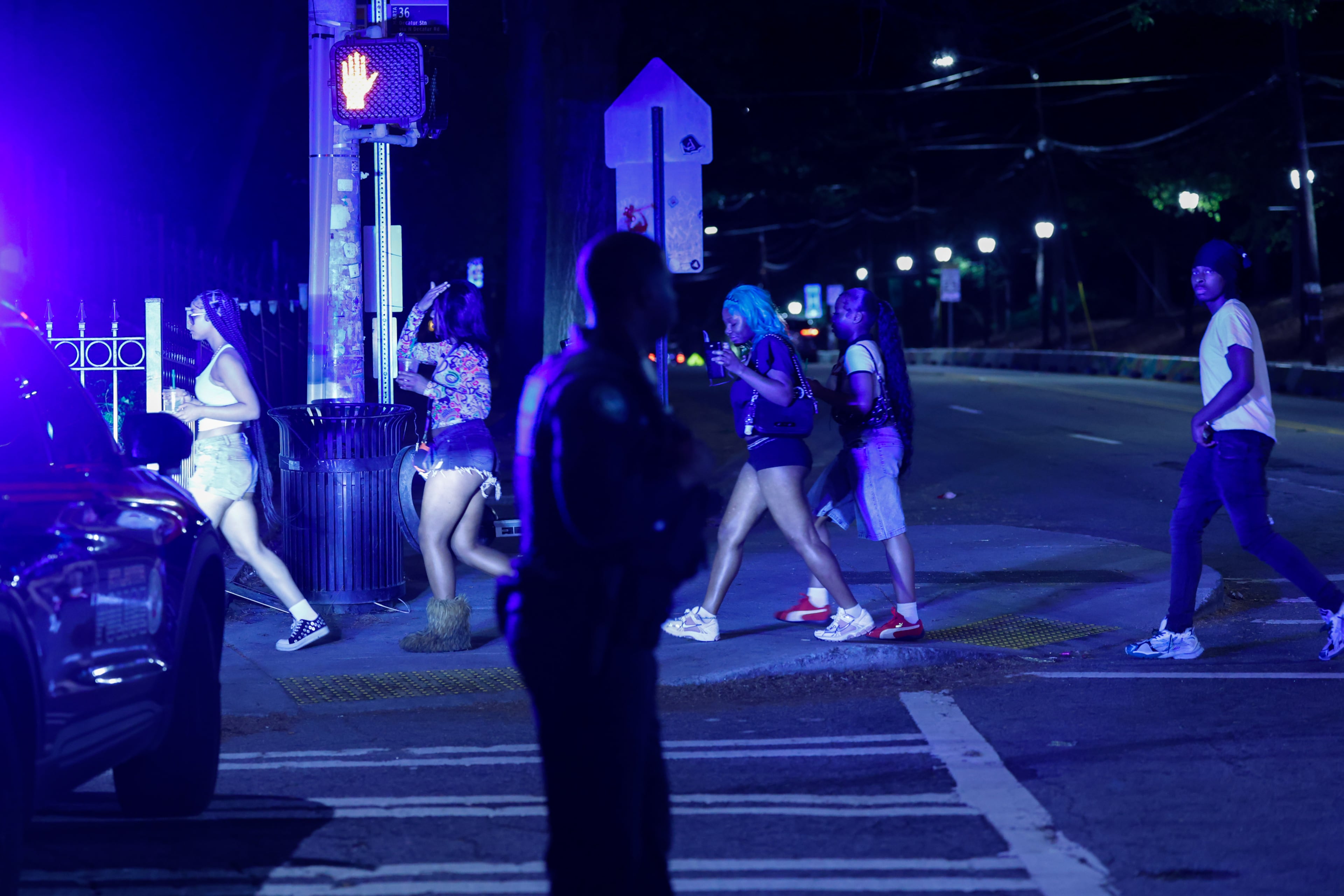 Pedestrians walk by as police block a street near Piedmont Park in Atlanta on April 4, 2026. A 16-year-old girl was killed, and a 15-year-old girl injured, in a shooting around 9 p.m. (Arvin Temkar/AJC)