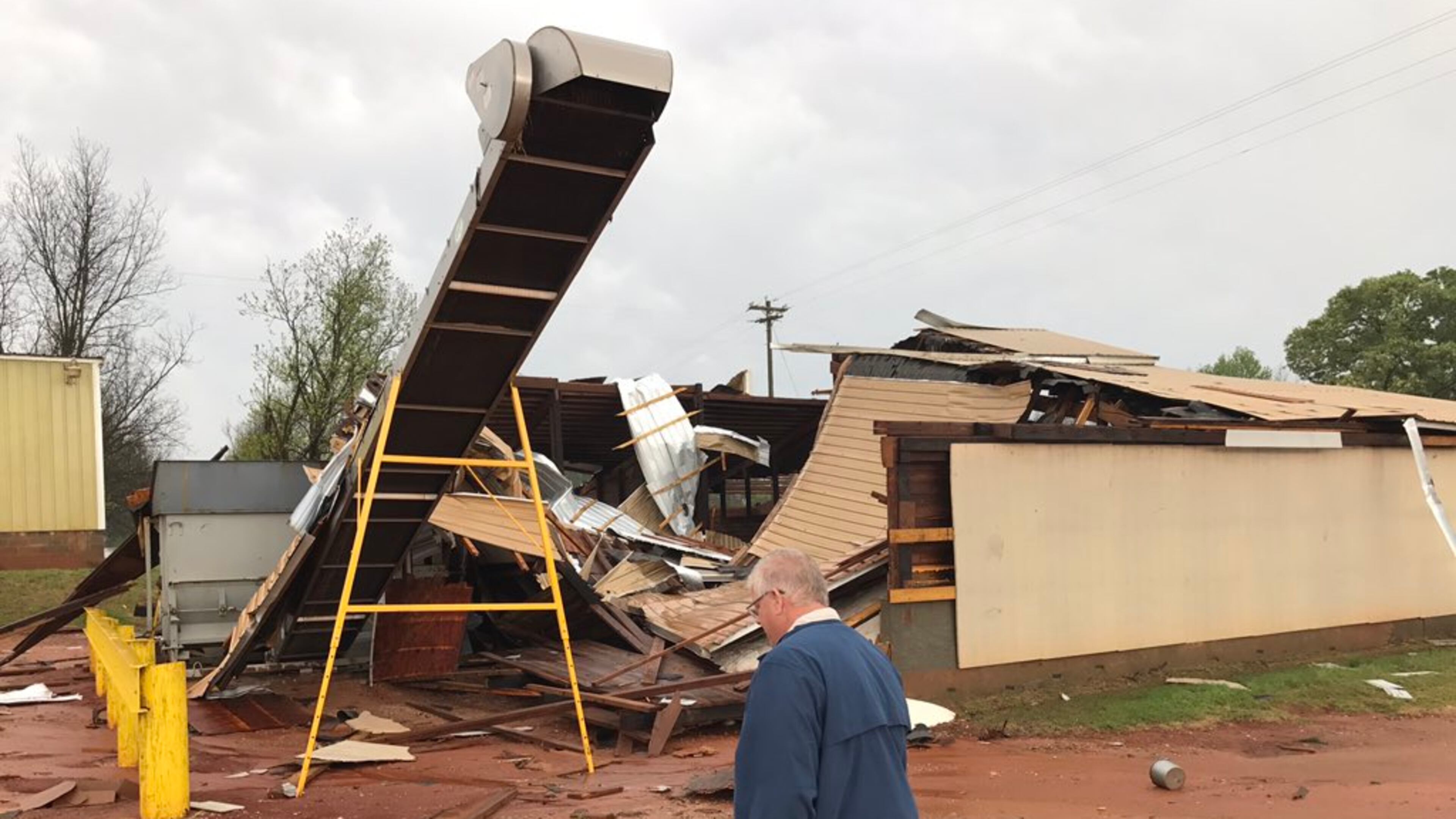 Mark Cox throws a piece of wood into the rubble that used to be his fertilizer building at Webster Farmers Inc. on Highway 520 in Webster County.