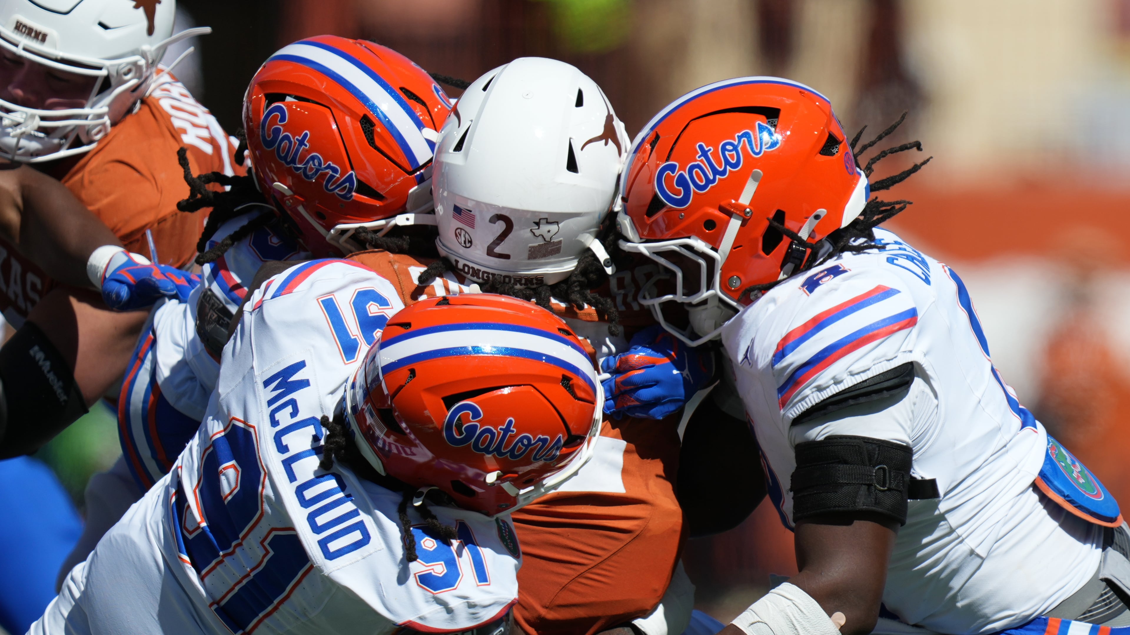 Texas running back Hollywood Smothers (2) is stopped by Florida defensive lineman Jeramiah McCloud (91) and linebacker Aaron Chiles (8) during the first half of an NCAA college football game in Austin, Texas, Saturday, Oct. 17, 2026. (AP Photo/Eric Gay)